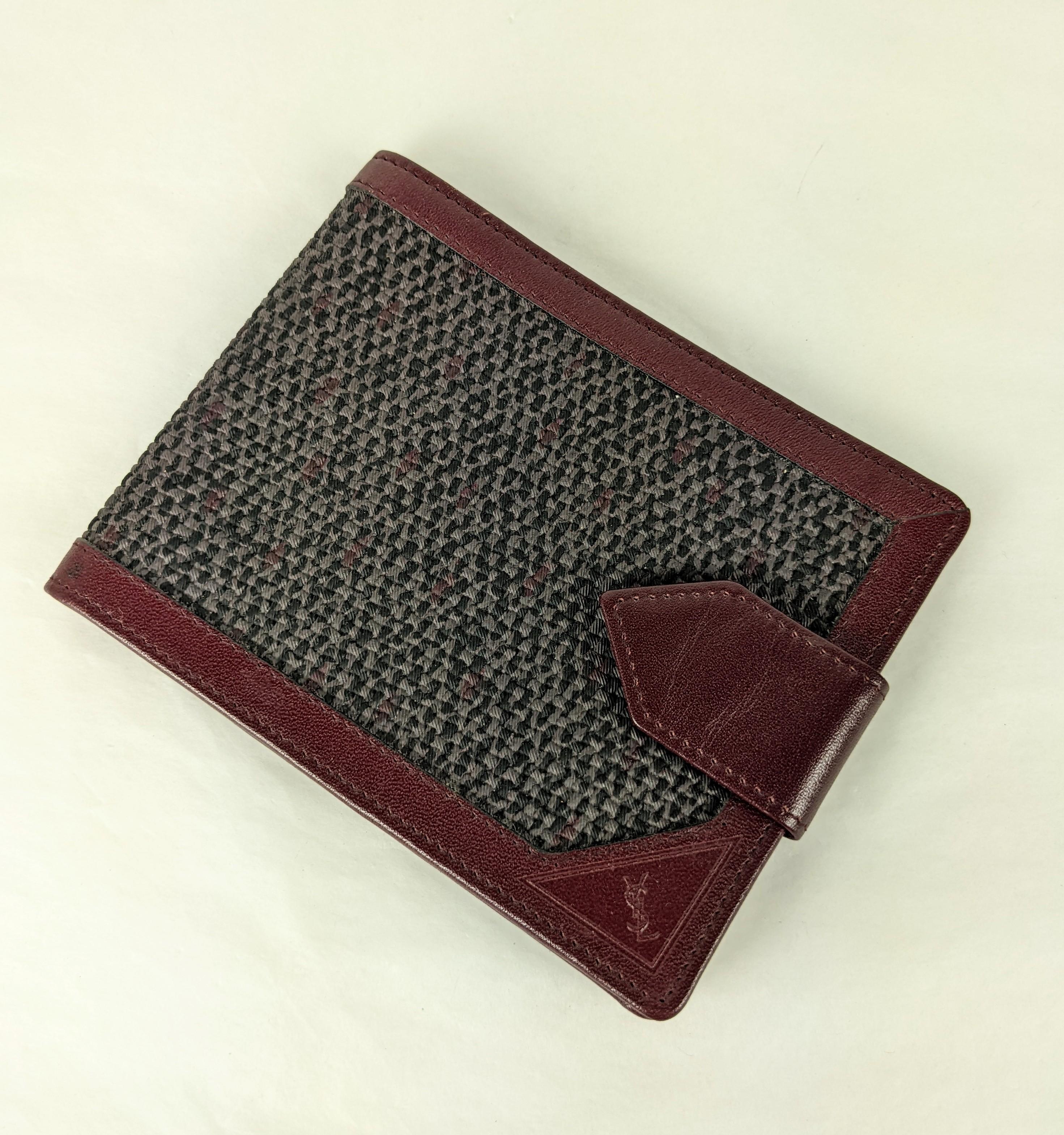 Yves Saint Laurent Faux Tweed Leather Fold designed as a check book fold. Slightly larger in scale than a normal wallet. Burgundy leather with faux tweed grey leather cover, snap tag and embossed YSL logo. 
Closed 5
