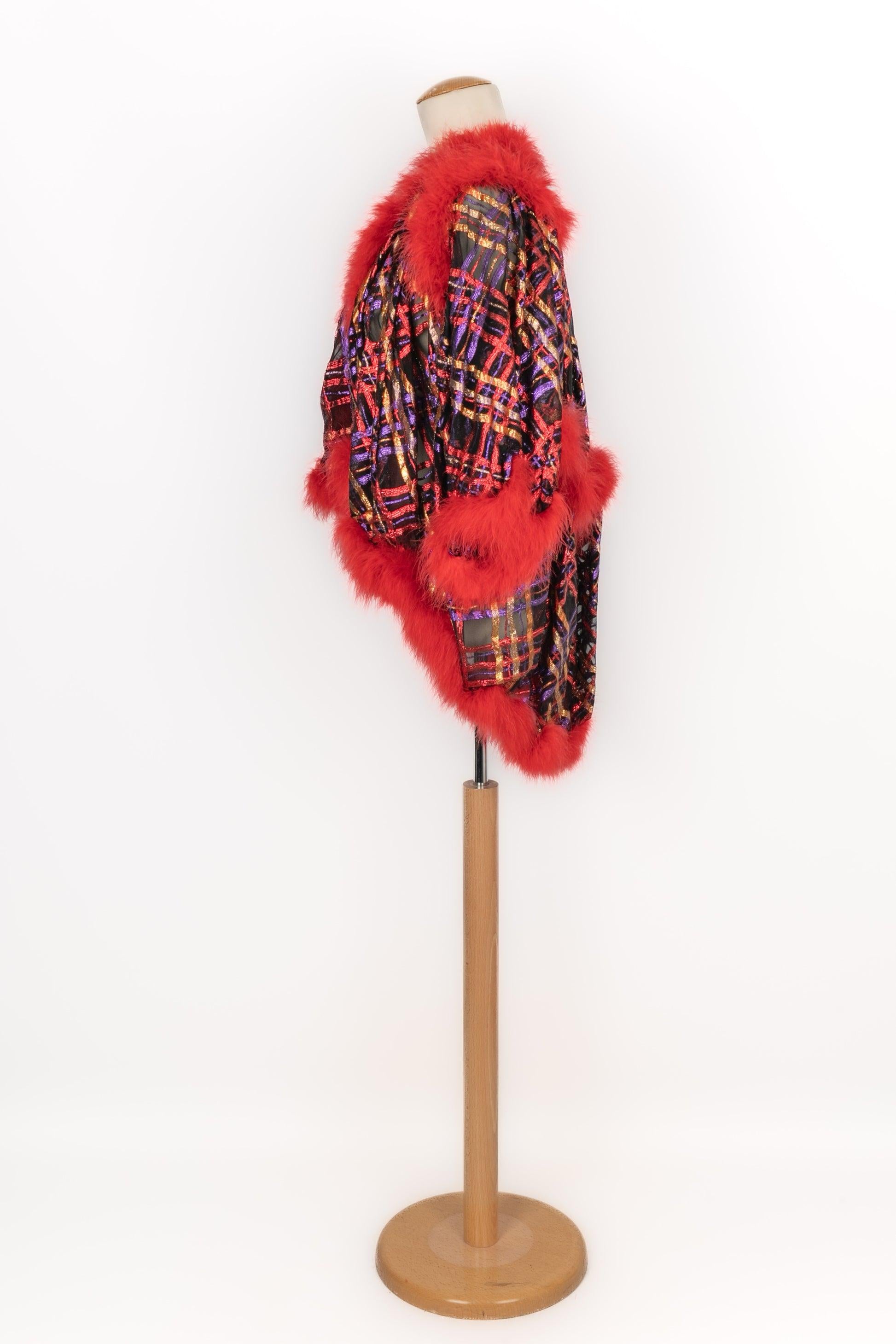 Yves Saint Laurent - (Made in France) Lamé and black muslin jacket edged with red feathers. Size 36FR. Piece from the 1980s. To be mentioned, the top of the left sleeve had been restored.

Additional information:
Condition: Good
