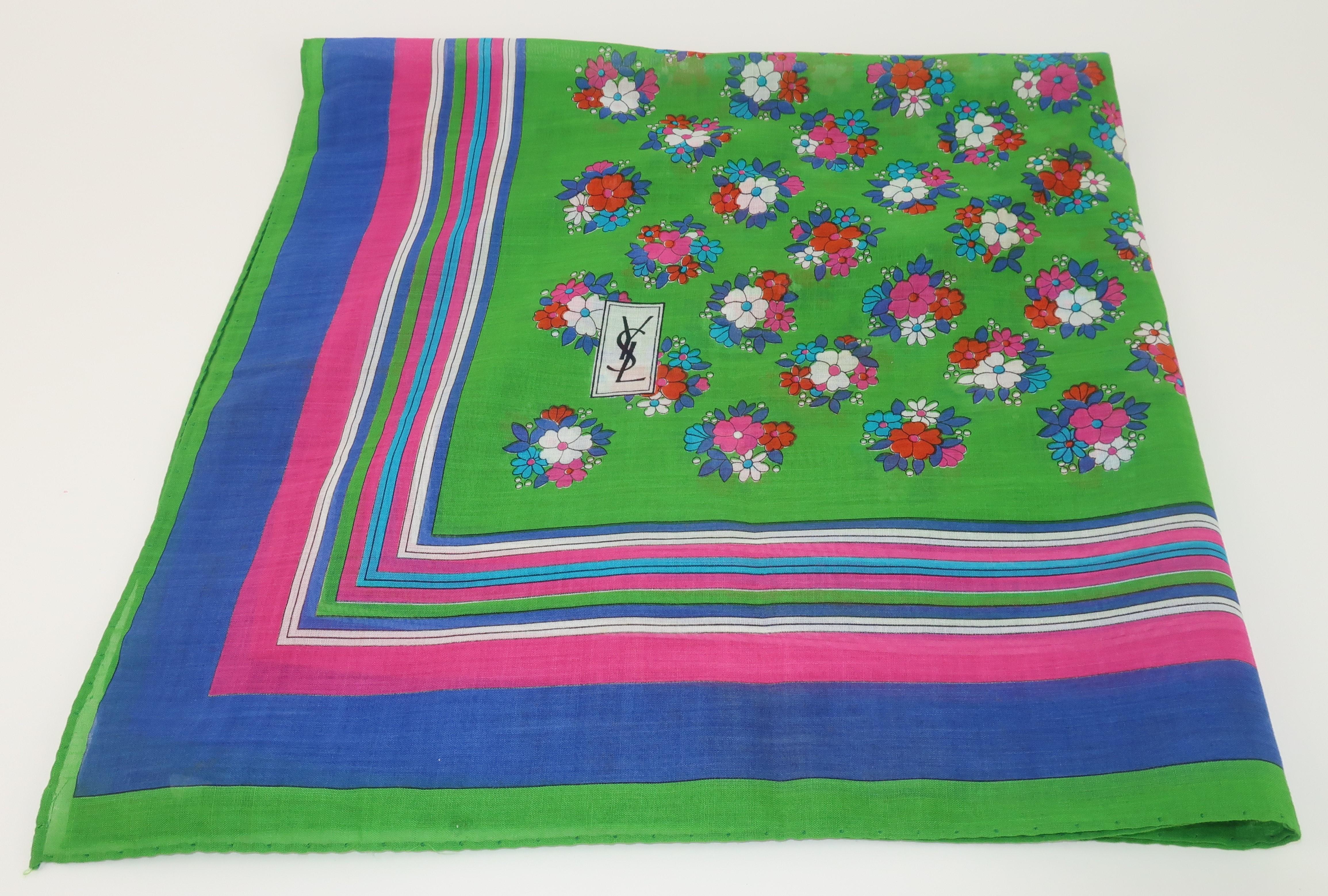 1970's Yves Saint Laurent fine cotton scarf with a floral bouquet print in shades of green, royal blue, hot pink, aqua blue, white and orangey-red.  The YSL logo is incorporated into the design and a 'Made in Italy' contents label attached to a