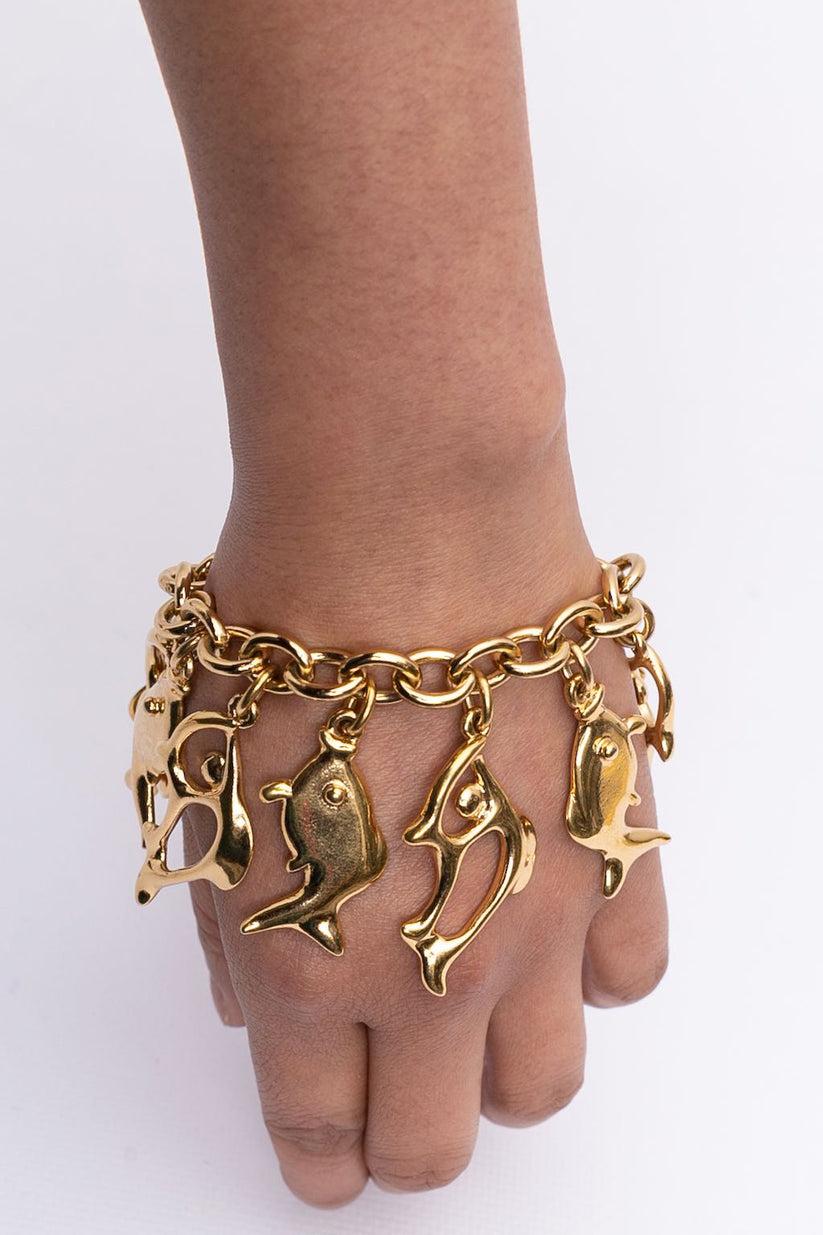 Yves Saint Laurent (Made in France) Bracelet en métal doré composé de breloques abstraites représentant des poissons.

Informations complémentaires :

Dimensions : 
Largeur : 5 cm (1.97 in) 
Longueur : 20 cm (7.87 in)

Condit : 
Très bon