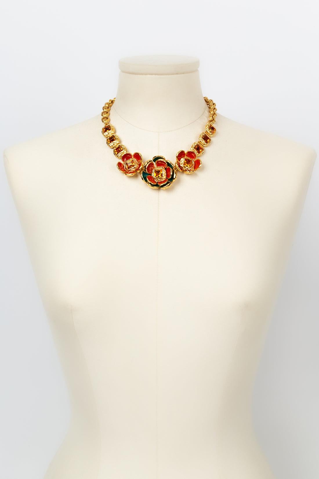 Yves Saint Laurent (Made in France) Short gilded metal necklace decorated with red and green enameled flowers paved with orange rhinestones.

Additional information: 
Dimensions: Length: 40 cm to 45 cm (15.74