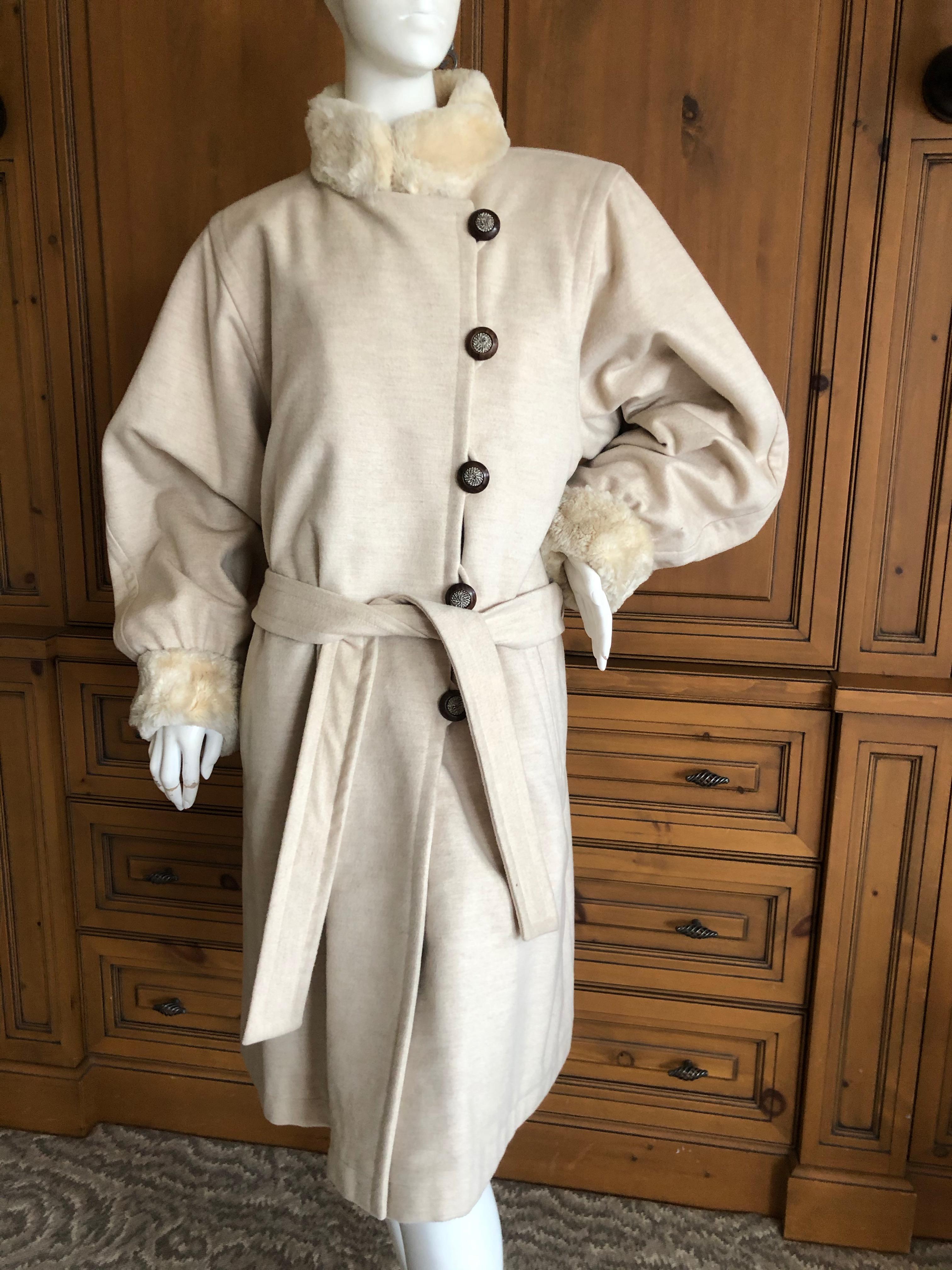 Yves Saint Laurent  Fourrures 1980's Ivory Fur Lined Coat
Styled with bold 1980's shoulders, it buttons down the front and belts for styling.
The fabric feels like a cashmere wool blend and I believe the fur is sheared beaver.
Sz 40
Bust 42