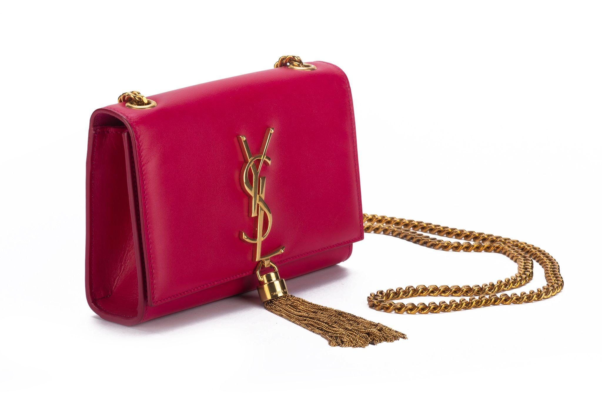 Yves Saint Laurent preloved fuchsia leather cross body bag with gold tassel and chain. Shoulder drop 23”. Comes with booklet and original dust cover.