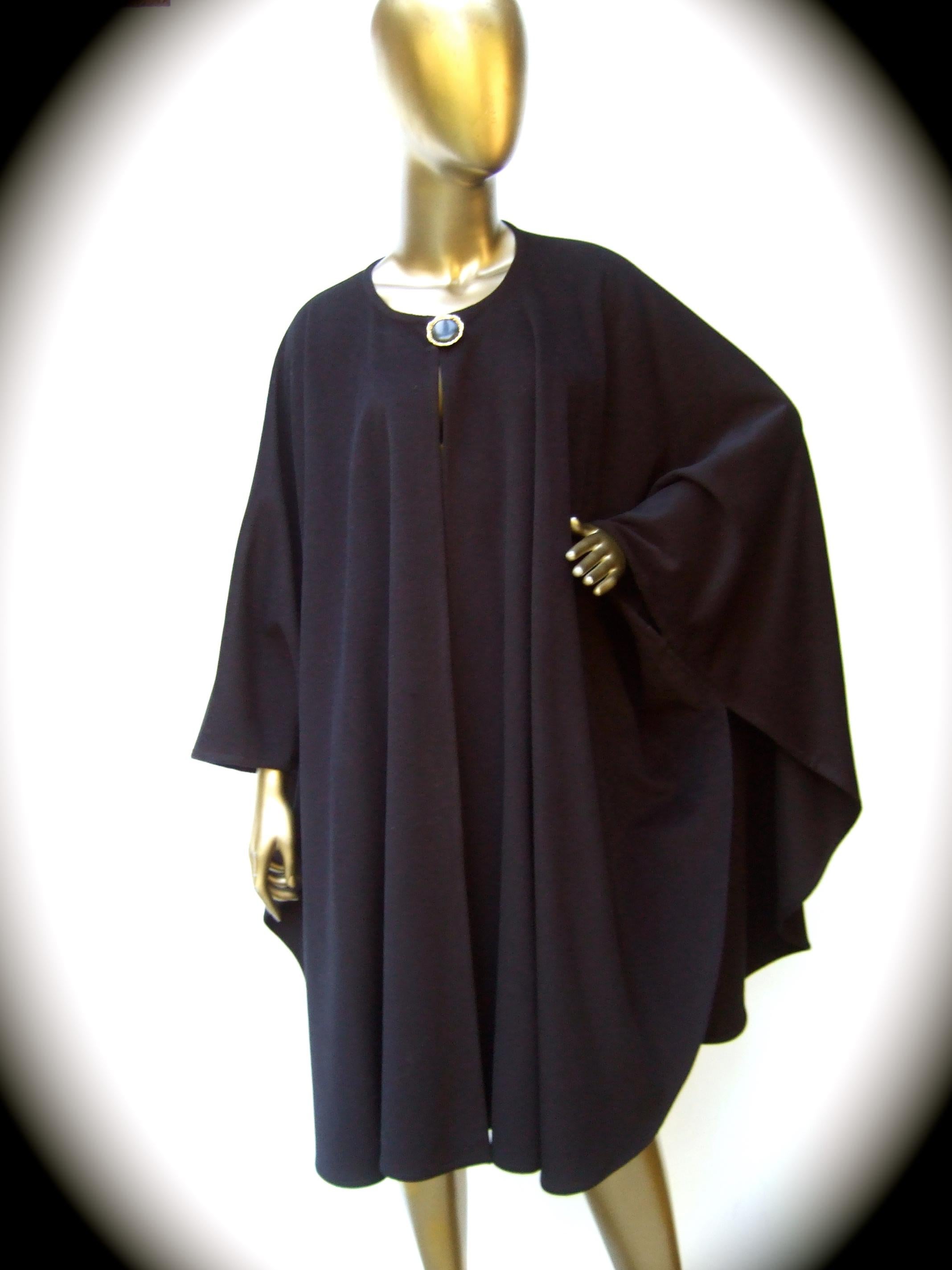 Yves Saint Laurent Fourrures Black cashmere cape c 1970s 
The stylish plush black cashmere cape secures with a single large
resin button 

The voluminous cape secures around the body with a pair of armhole slits
Makes a timeless chic garment 

The