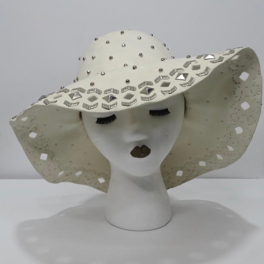 Do not miss out on this stunning vintage Yves Saint Laurent hat! The silver gems and cut out detailing throughout make this such a statement piece that will take any outfit from drab to fab. The floppy style can be easily adjusted to suit any face