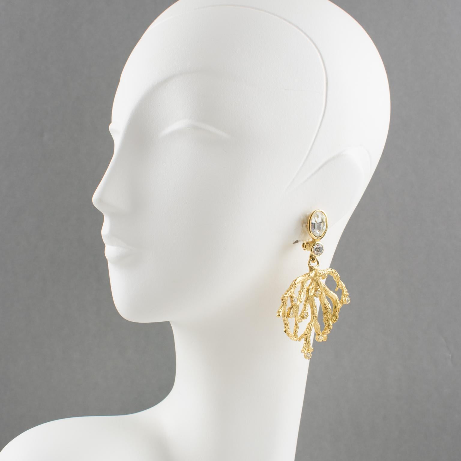 Fabulous Yves Saint Laurent Paris signed clip-on earrings. Gilt metal dangling shape with hand-made feel textured pattern, carved and see-thru branch design complements with clear crystal rhinestones. YSL signature logo engraved on fastenings with