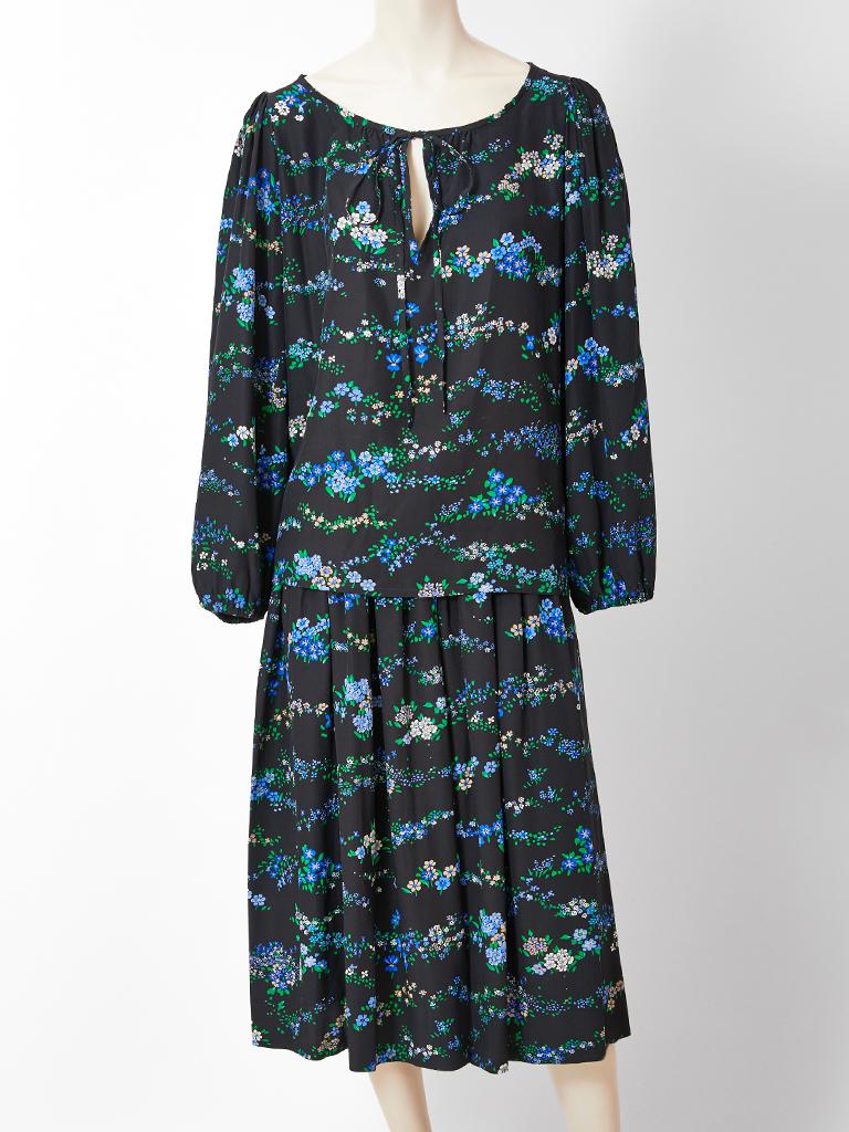 Yves Saint Laurent, Rive Gauche, silk, two piece, floral pattern, peasant ensemble. Colorful, floral print in shades of turquoise and green on a black ground. Blouse has an open neck with a tie and a center slit and balloon sleeves with elastic at