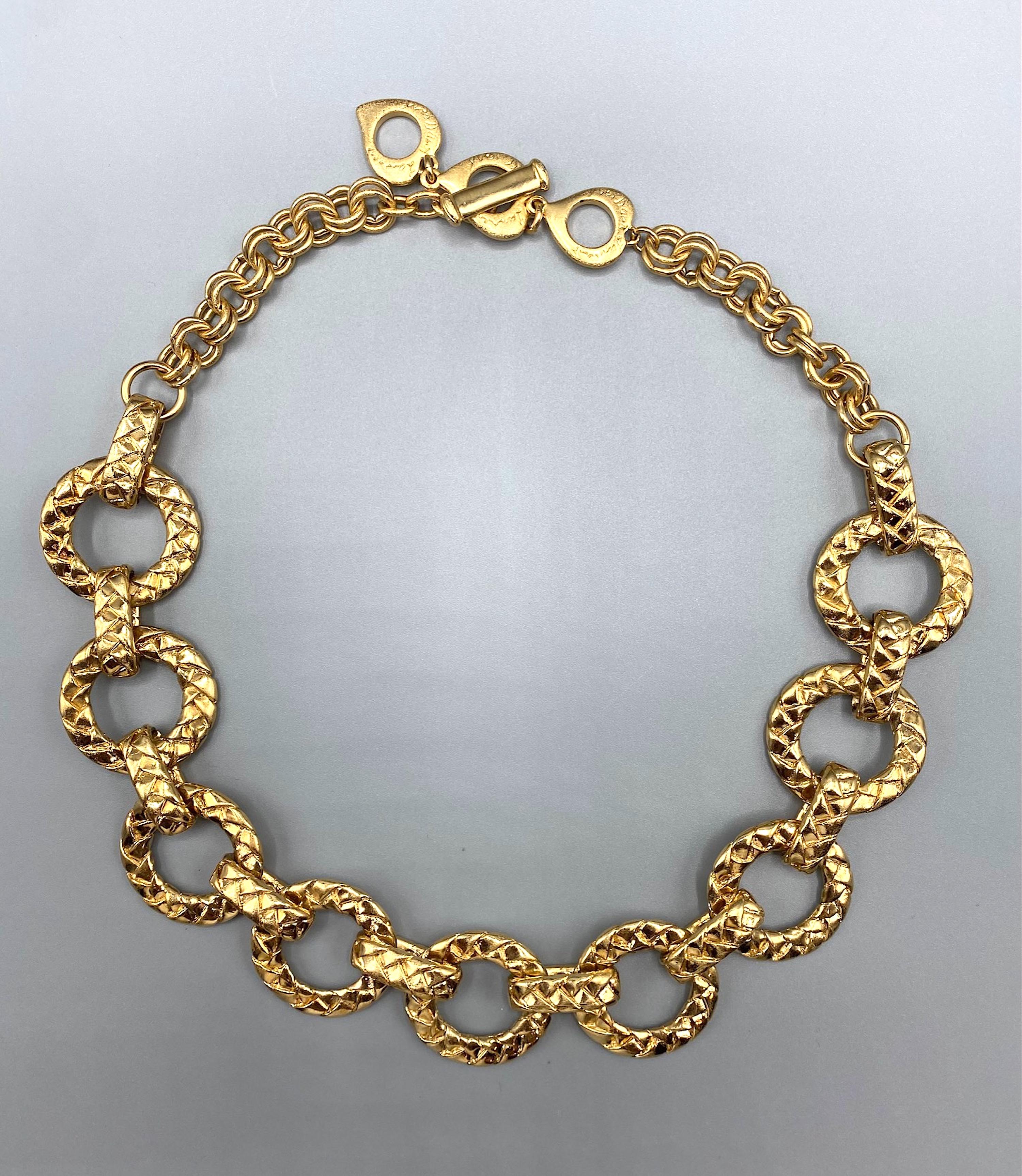 A wonderful 1980's example of Yves Saint Laurent bijoux. The necklace is comprised of 9 round and 10 oval connector links in the front and all done with a cast quilt design. These front quilt links have a double round link chain on each end. One