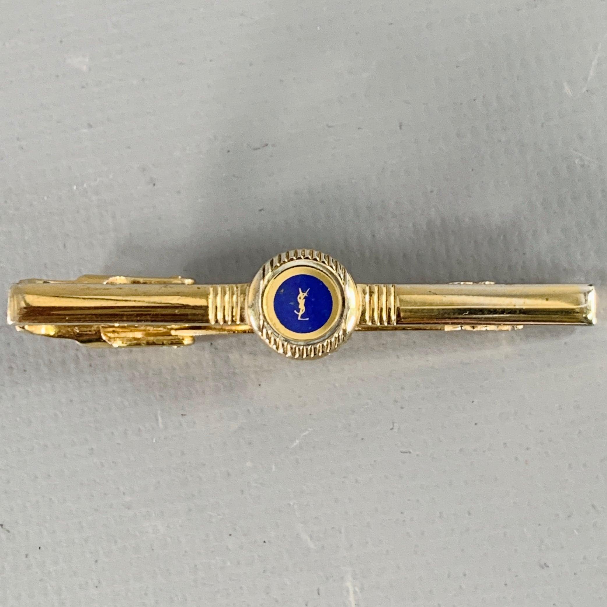 YVES SAINT LAURENT tie clip
in a gold tone metal featuring a blue circle with YSL logo detail. Comes with box.Excellent Pre-Owned Condition with Box.Width: 2 inches 
  
  
 
Sui Generis Reference: 136639
Category: Tie Clip
More Details
    
Brand: 