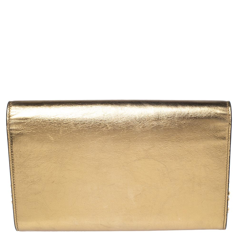 With a classic and chic style, this Yves Saint Laurent Kate clutch will take a special place in your collection for years to come. Crafted in Italy, it is made from gold leather and is held by a shoulder chain. The front flap is enhanced with the