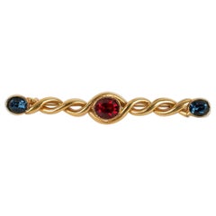 Yves Saint Laurent Broche en métal doré avec strass rouges et bleus