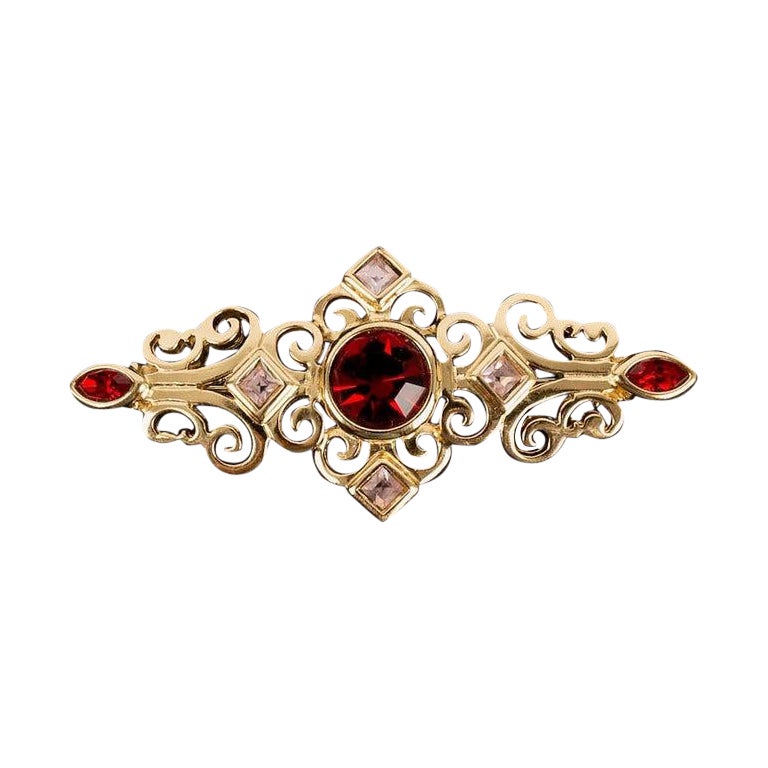 Broche Yves Saint Laurent en métal plaqué or et strass