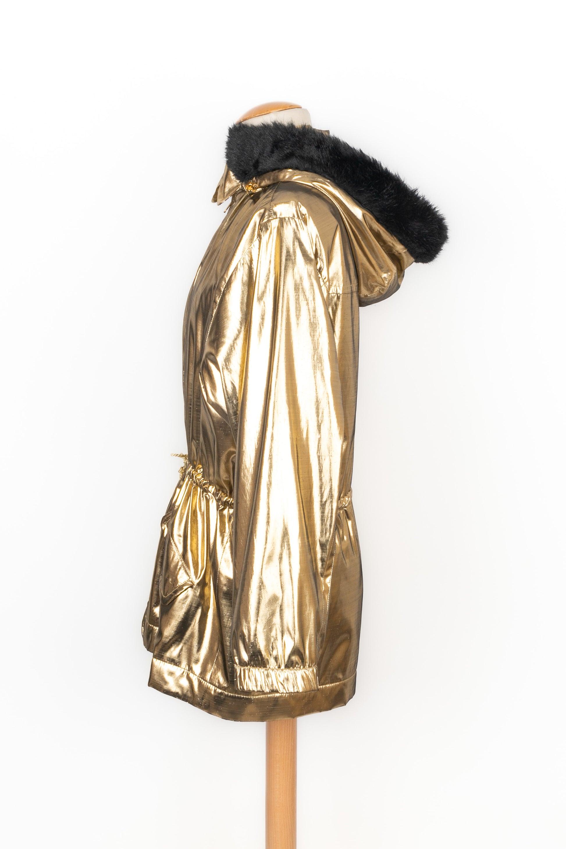 Yves Saint Laurent - (Made in France) Golden lurex hooded coat. The hood is edged with black faux-fur. Size 40FR indicated. 1991 Fall-Winter variation Collection.

Additional information:
Condition: Good condition
Dimensions: Shoulder width: 42 cm -