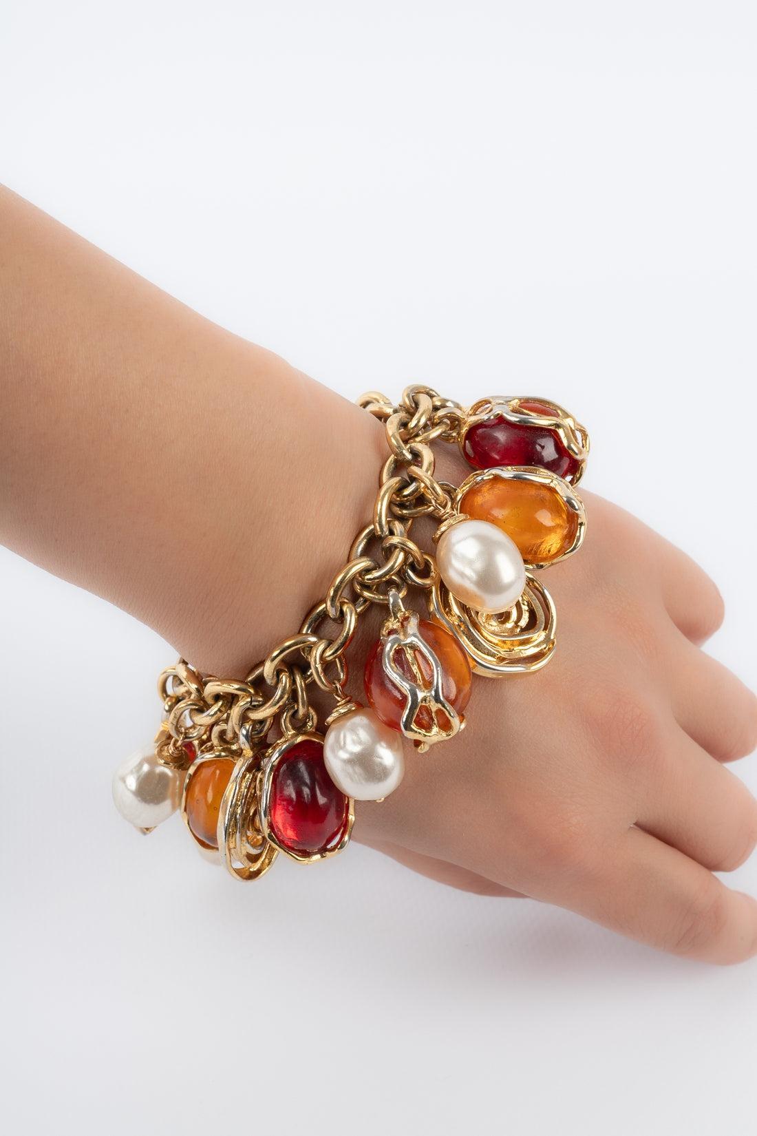 Yves Saint Laurent - (Made in France) Golden metal bracelet with costume pearls and resin cabochons.

Additional information:
Condition: Very good condition
Dimensions: Length: from 18 cm to 21 cm

Seller Reference: BRA46
