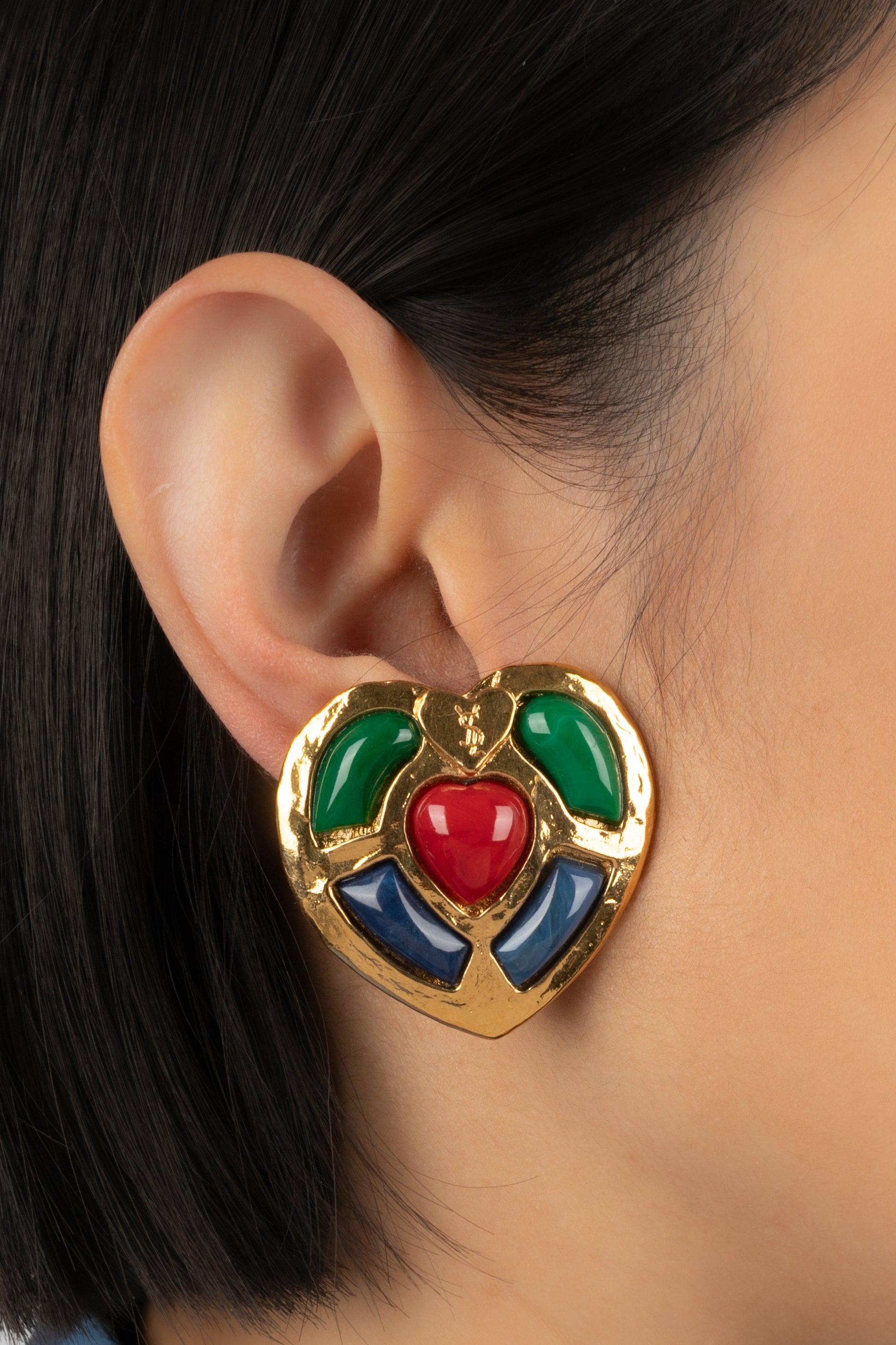 Yves Saint Laurent - (Made in France) Golden metal clip-on earrings with glass paste cabochons, representing a heart. Jewelry from the middle of the 1980s.

Additional information:
Condition: Very good condition
Dimensions: 4 cm x 4 cm
Period: 20th