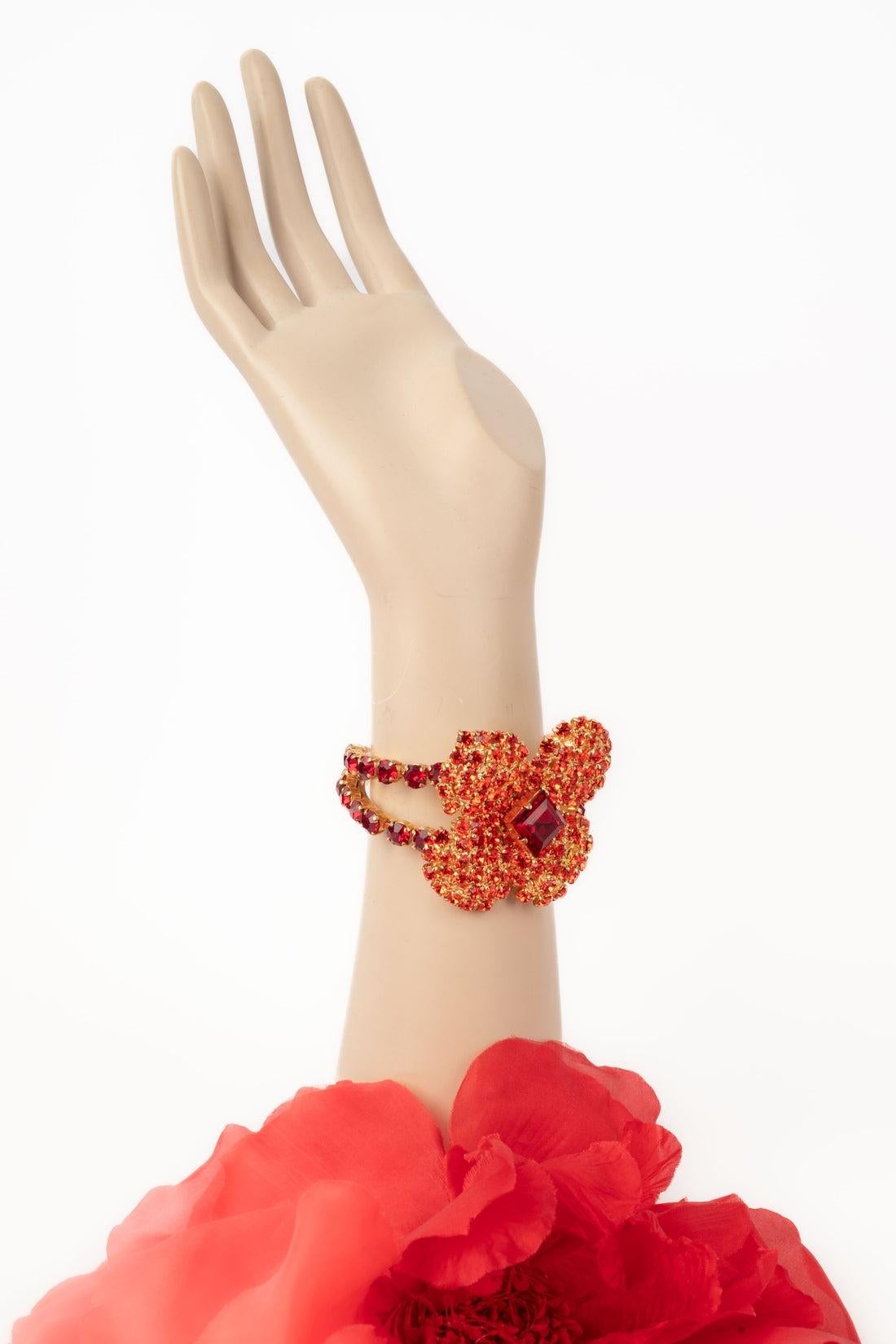 Yves Saint Laurent - (Made in France) Golden metal rigid bracelet ornamented with rhinestones representing a flower.

Additional information:
Condition: Very good condition
Dimensions: Length: 13 cm - Opening: 2 cm 

Seller Reference: BRA33