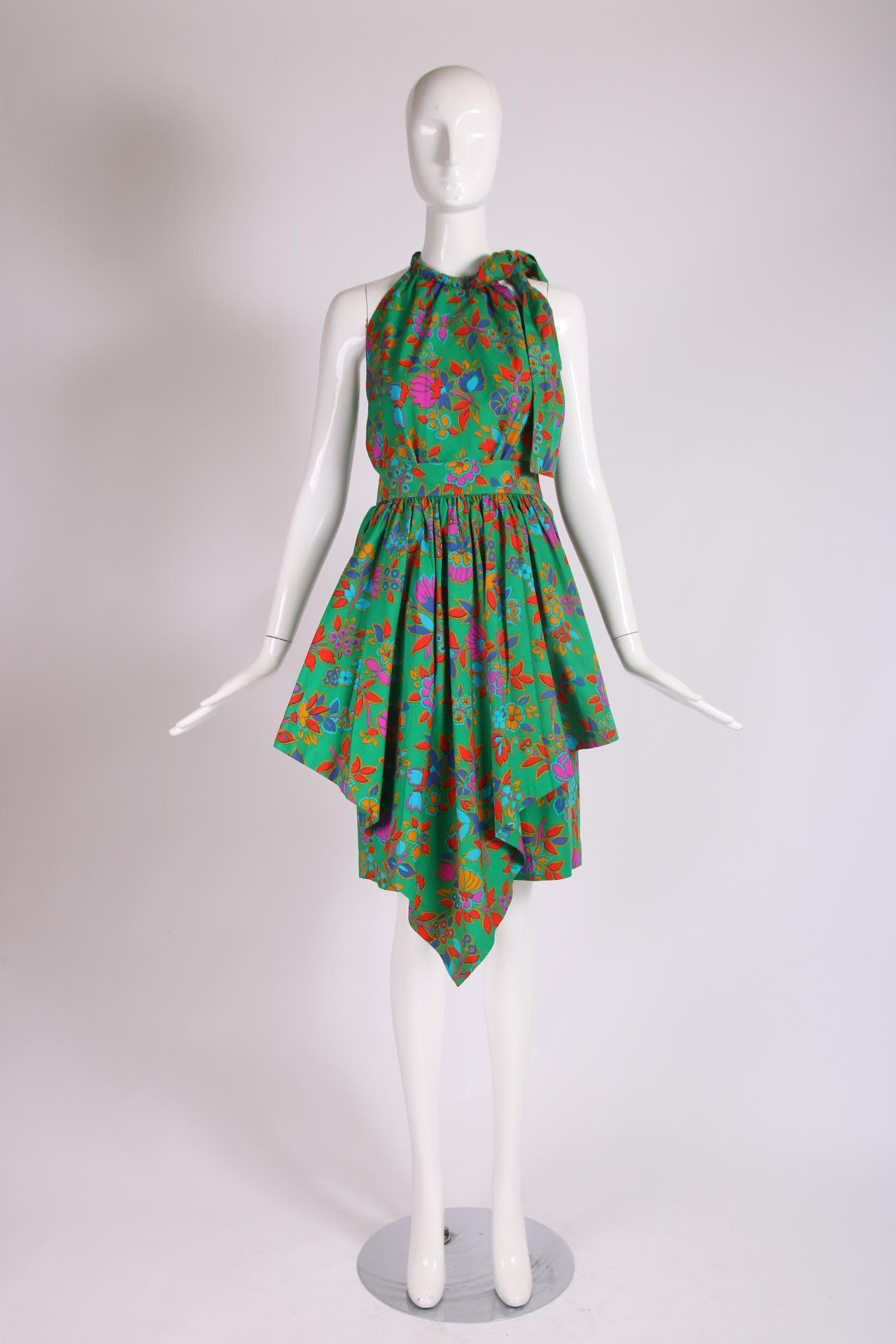 Ca. 1981 YSL 3-piece floral print ensemble comprised of a halter top which tucks into a skirt that is completely open at both sides and is worn over a pair of Bermuda style shorts. Based on its construction, when the three pieces are worn together,