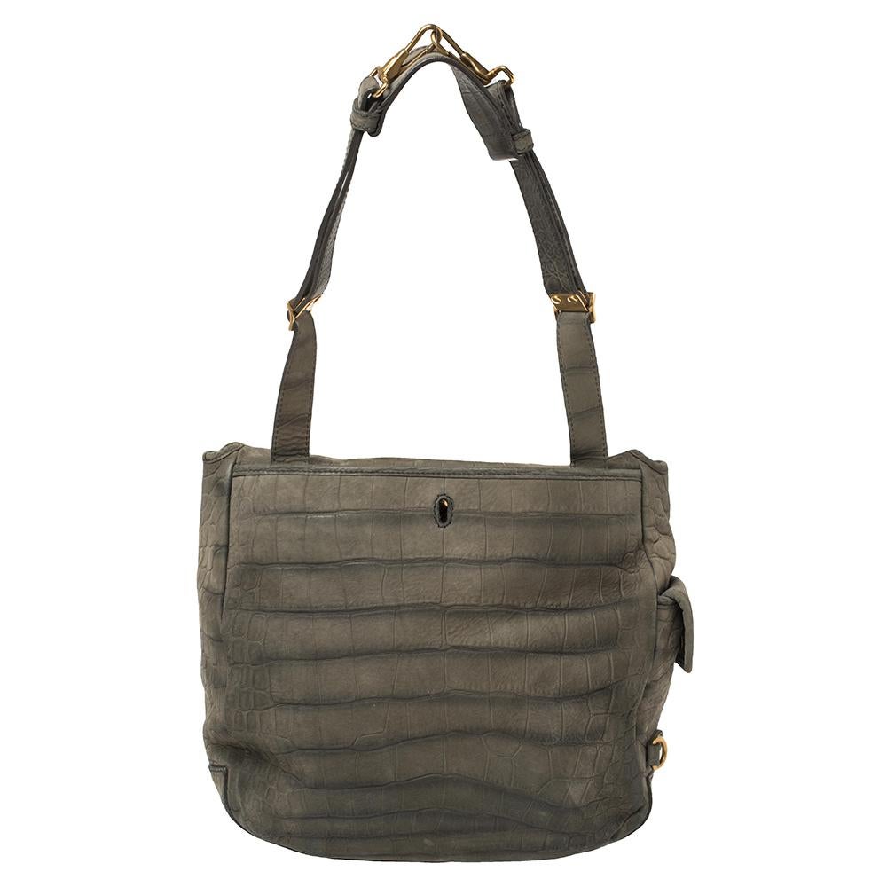 As the universe of handbags expands with varied choices, it is wise to opt for pieces that are functional and stylish at the same time, just like this Besace shoulder bag from Yves Saint Laurent. Created from croc-embossed suede, the bag has a green