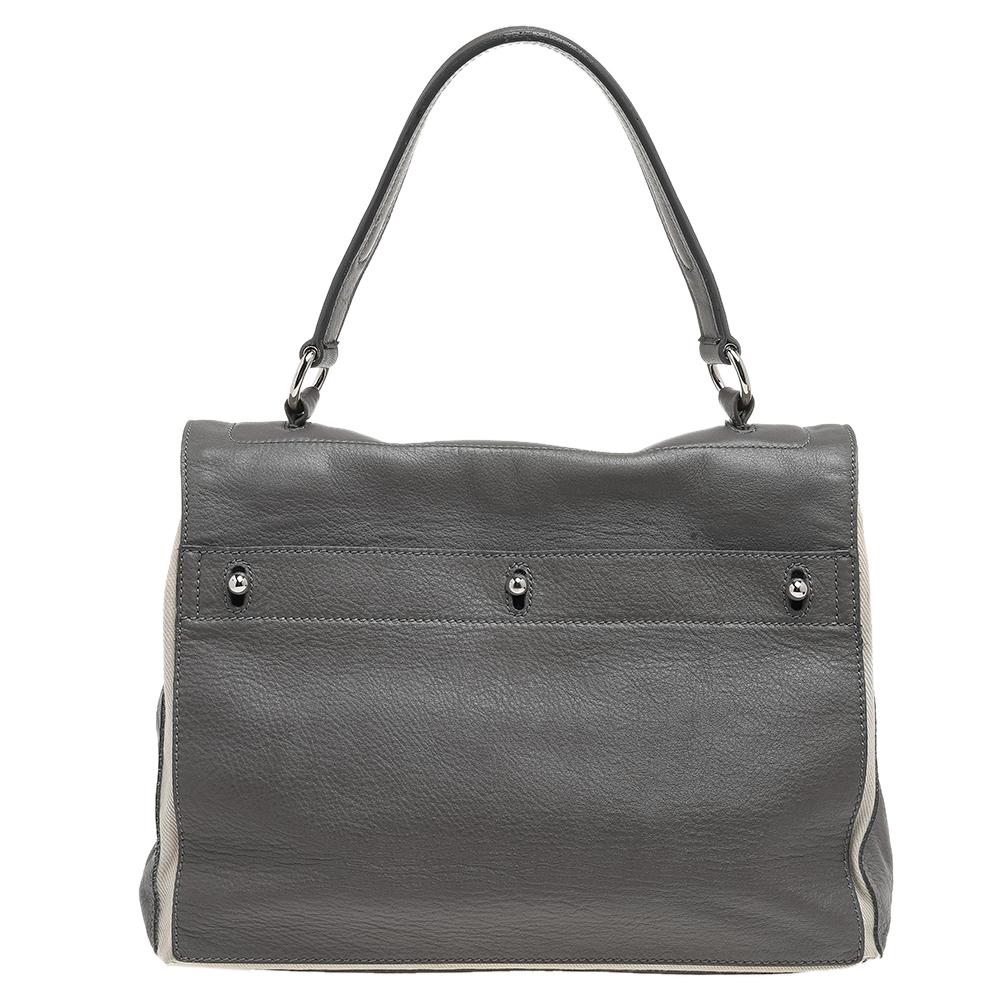 Make everyone nod in approval when you step out swaying this Yves Saint Laurent bag. It has been crafted from white & grey leather & canvas and held by a top handle. The bag has a flap that leads to a spacious canvas interior and it is perfectly