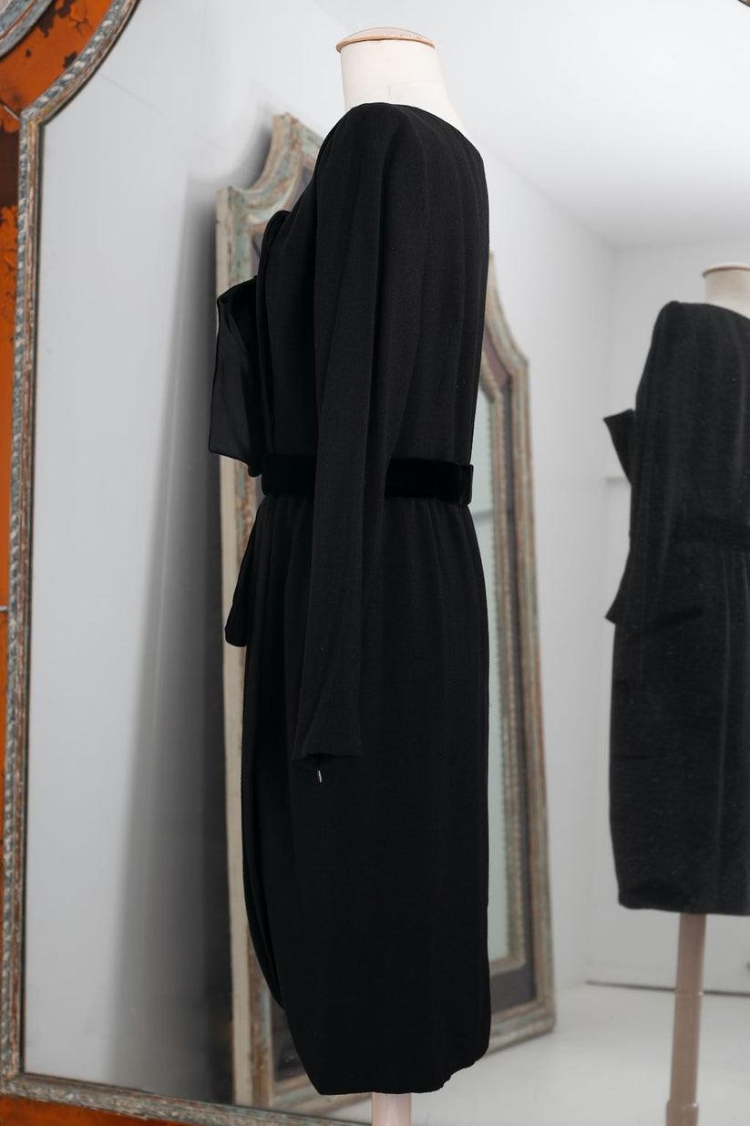 Yves Saint Laurent Haute Couture - Very nice dress in black wool crepe, fastening with a slanting snap closure that continues on to the wrap skirt. 
The waist is underlined with a velvet bow. 
Circa 1999. 
Ribbon N°67470
No composition or size tag,