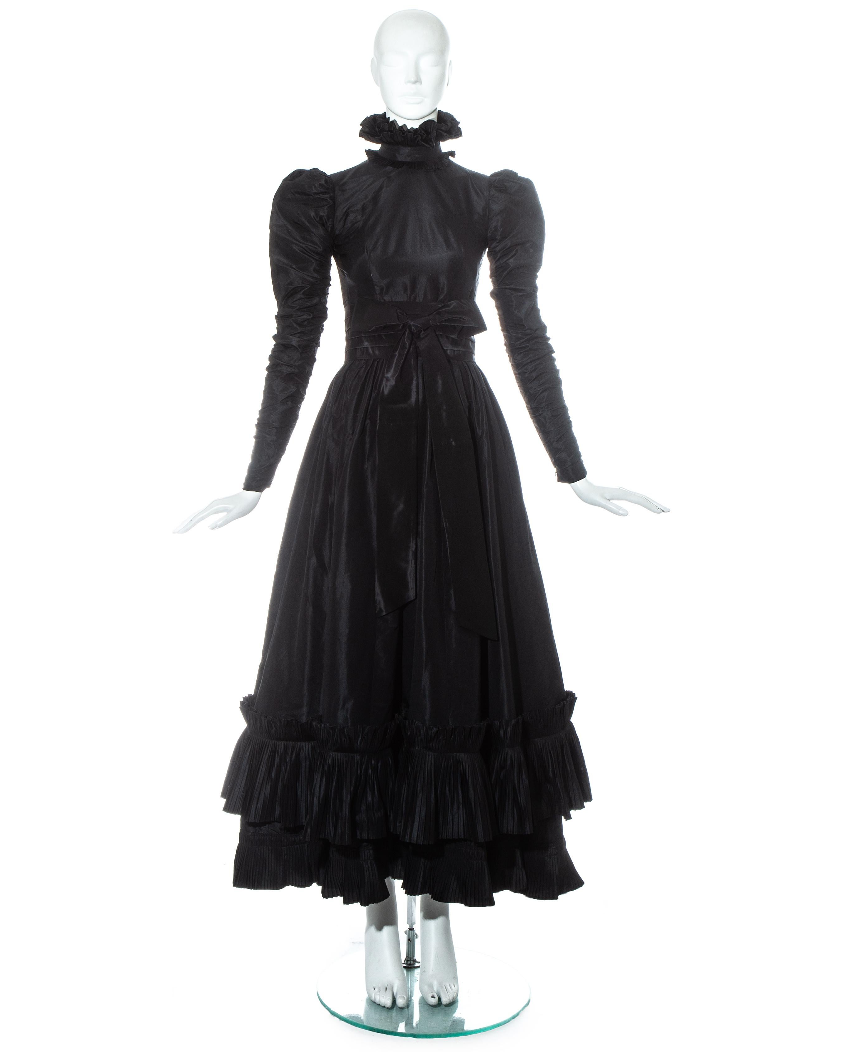 Yves Saint Laurent Haute Couture black silk taffeta evening dress.

- Puff shoulders with ruched sleeves
- High neck with accordion pleated ruffled trim
- Full skirt with accordion pleated ruffled trim 
- Pleated waist belt with decorative bow 
-