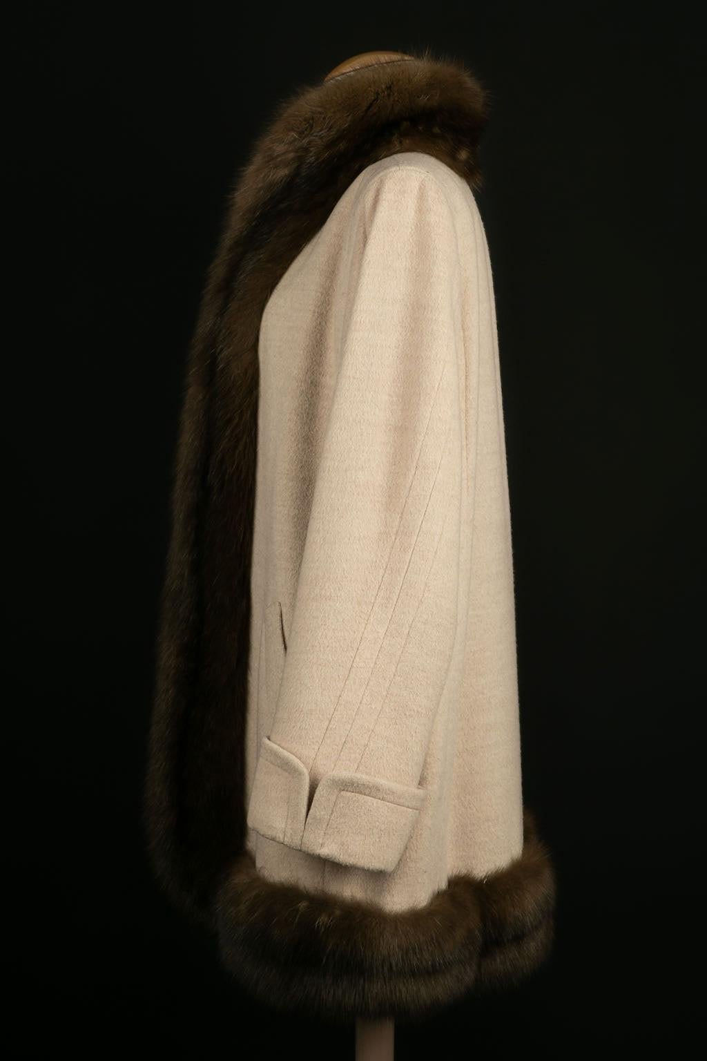 Yves Saint Laurent -Haute Couture coat in ecru wool trimmed with Russian sable. Bolduc 69491, circa 1994. No composition or size label, it fits a size 38FR/40FR. Some wear marks on the sleeves.

Additional information: 
Dimensions: Shoulder width:
