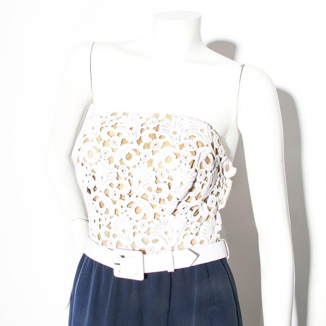 Haute Couture Lace Dress by Yves Saint Laurent 
White lace detail on bust
White detachable belt 
Navy skirt
Sleeveless
Strapless
Structured bust
Scoop cut out on back 
Column silhouette
Left side zip down closure with hook and eye and snap
Silk