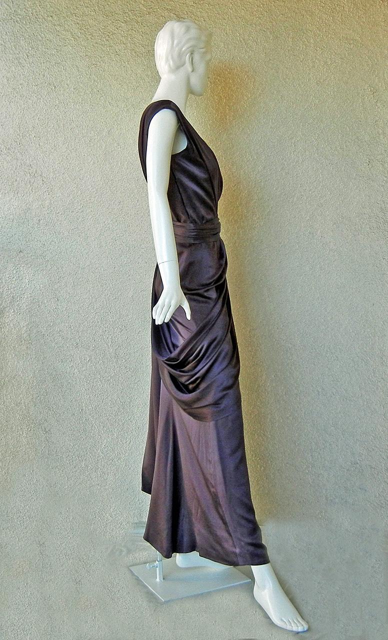 Une superbe robe en charmeuse de soie d'un prune profond, créée par Yves Saint Laurent à partir de sa Collection Haute Couture vers 1997-98. Le style et les couleurs s'inspirent de l'ancien design swag du designer, datant du début des années 1970.