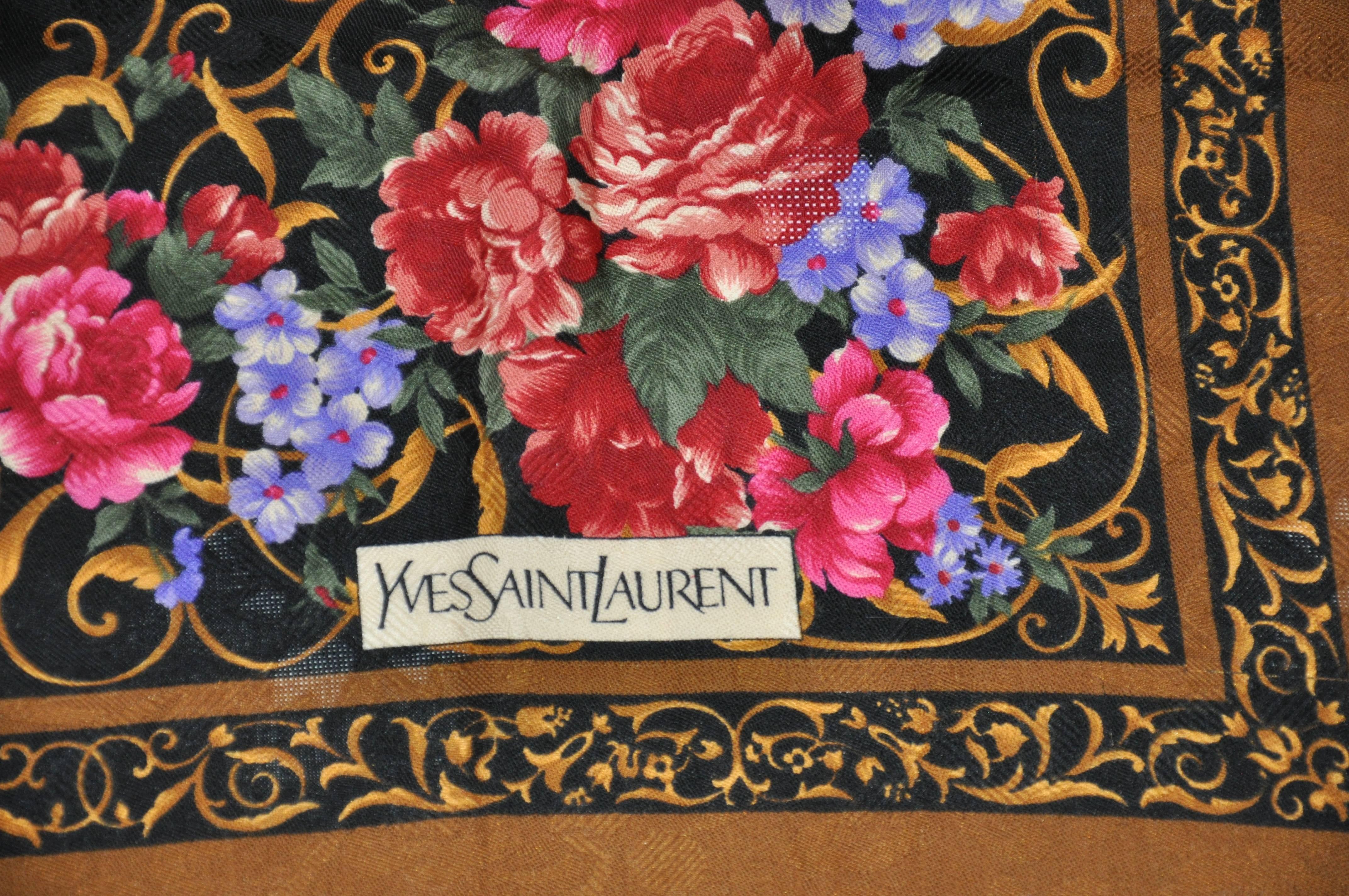        L'enorme bordo marrone cacao di Yves Saint Laurent che circonda un centro floreale multicolore è realizzato in challis di lana proveniente dalla Francia. Questa enorme sciarpa misura 43 pollici per 44 pollici. Prodotto in Francia. Ci sono