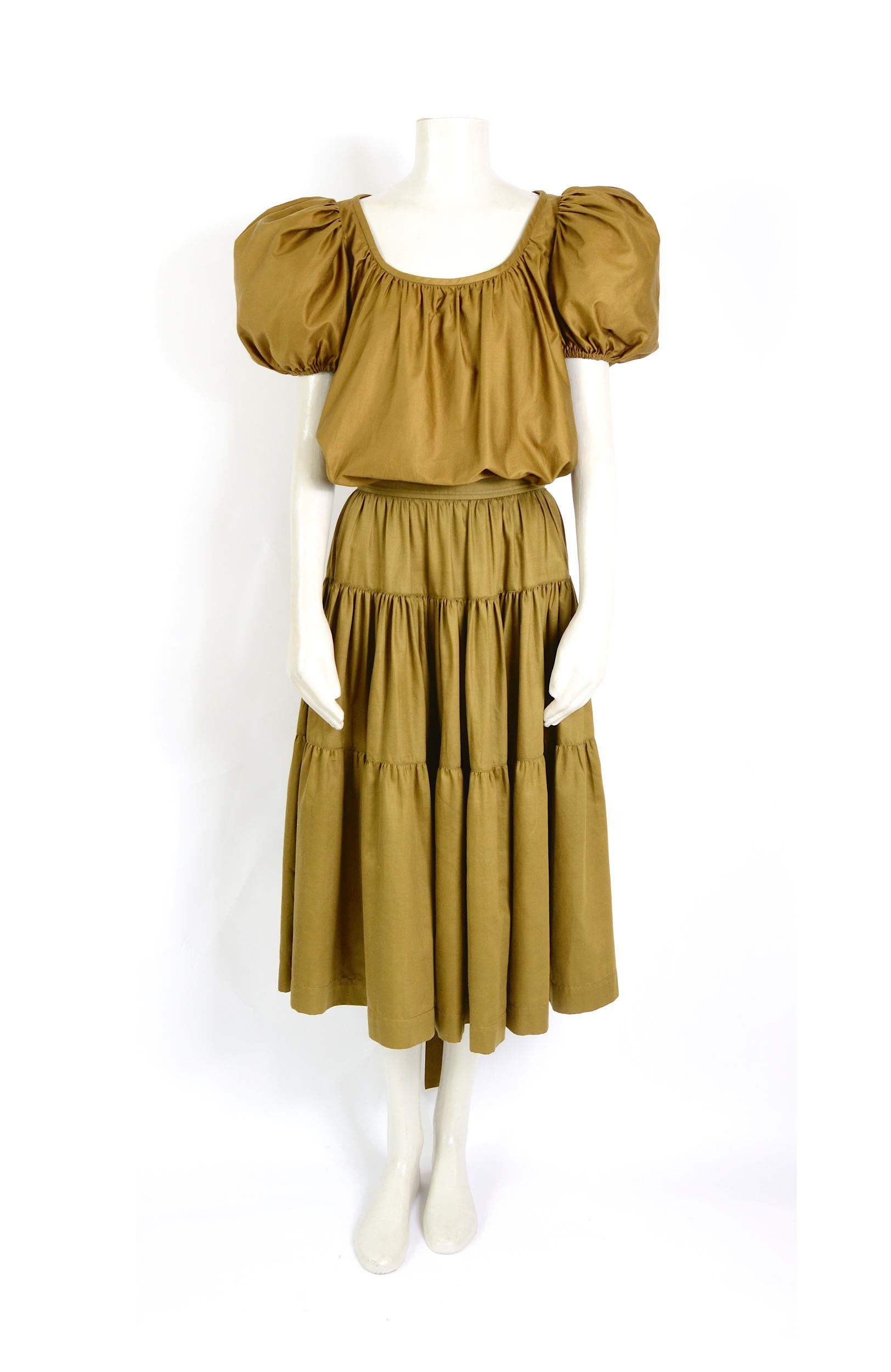 This beautiful collectible iconic vintage 1970s blouse and skirt set by Yves Saint Laurent clearly illustrates Yves Saint Laurent's love and fascination for all things gypsy and bohemian.
The unlined skirt and top plus a tie sash belt are made in