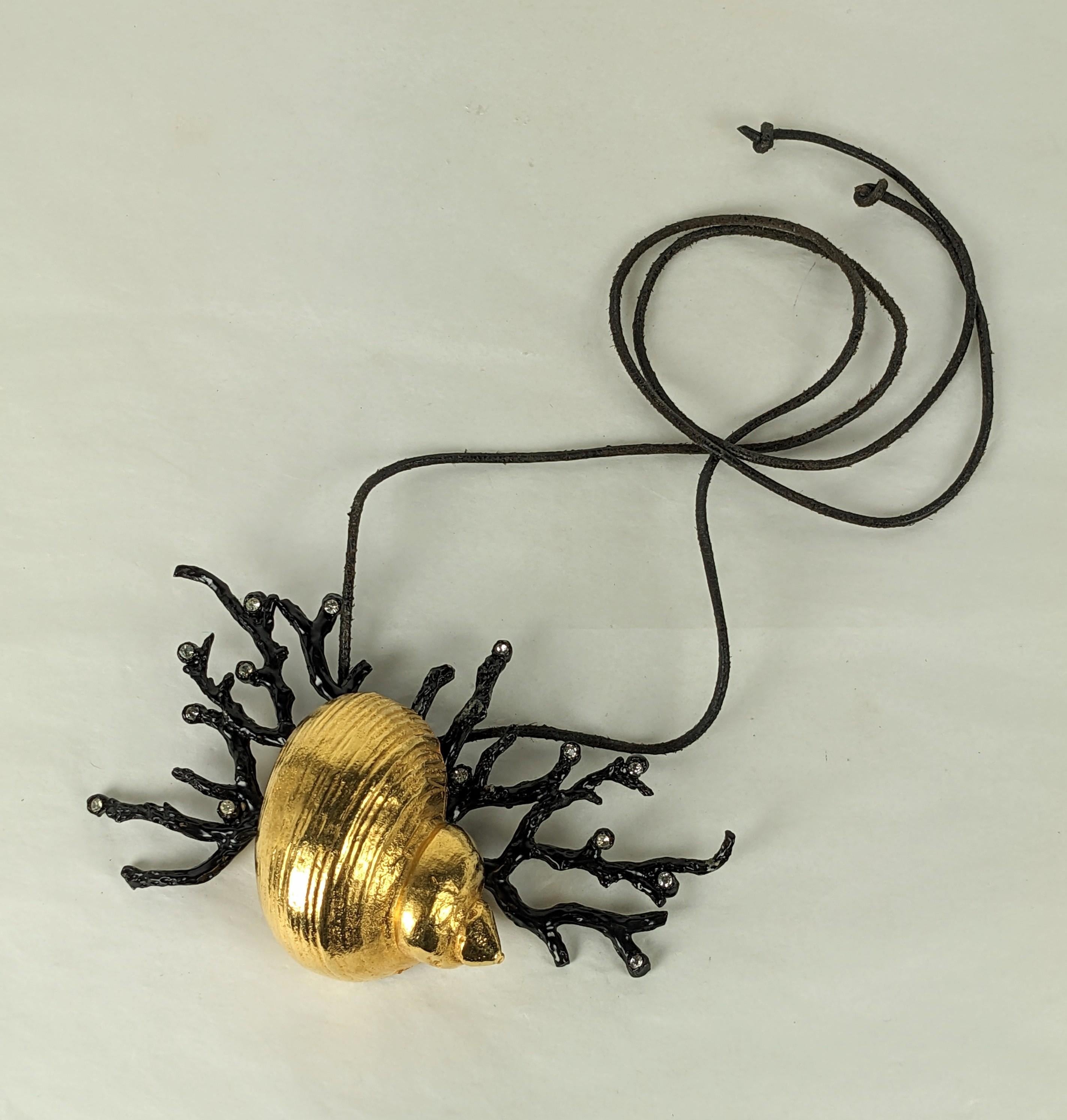 Incredibilmente raro ciondolo a forma di conchiglia di corallo di Yves Saint Laurent, Maison Goossens. Grande conchiglia centrale in bronzo dorato con rami di corallo smaltati a freddo e arricchiti da paste di cristallo. Corda di cuoio originale.