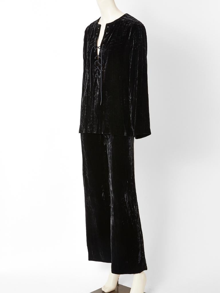 Yves Saint Laurent black, crushed velvet tunic and pant ensemble, c. 1970's.
Tunic is Saharienne style, having a laced neckline. Pant has a fly front and is semi wide legged.