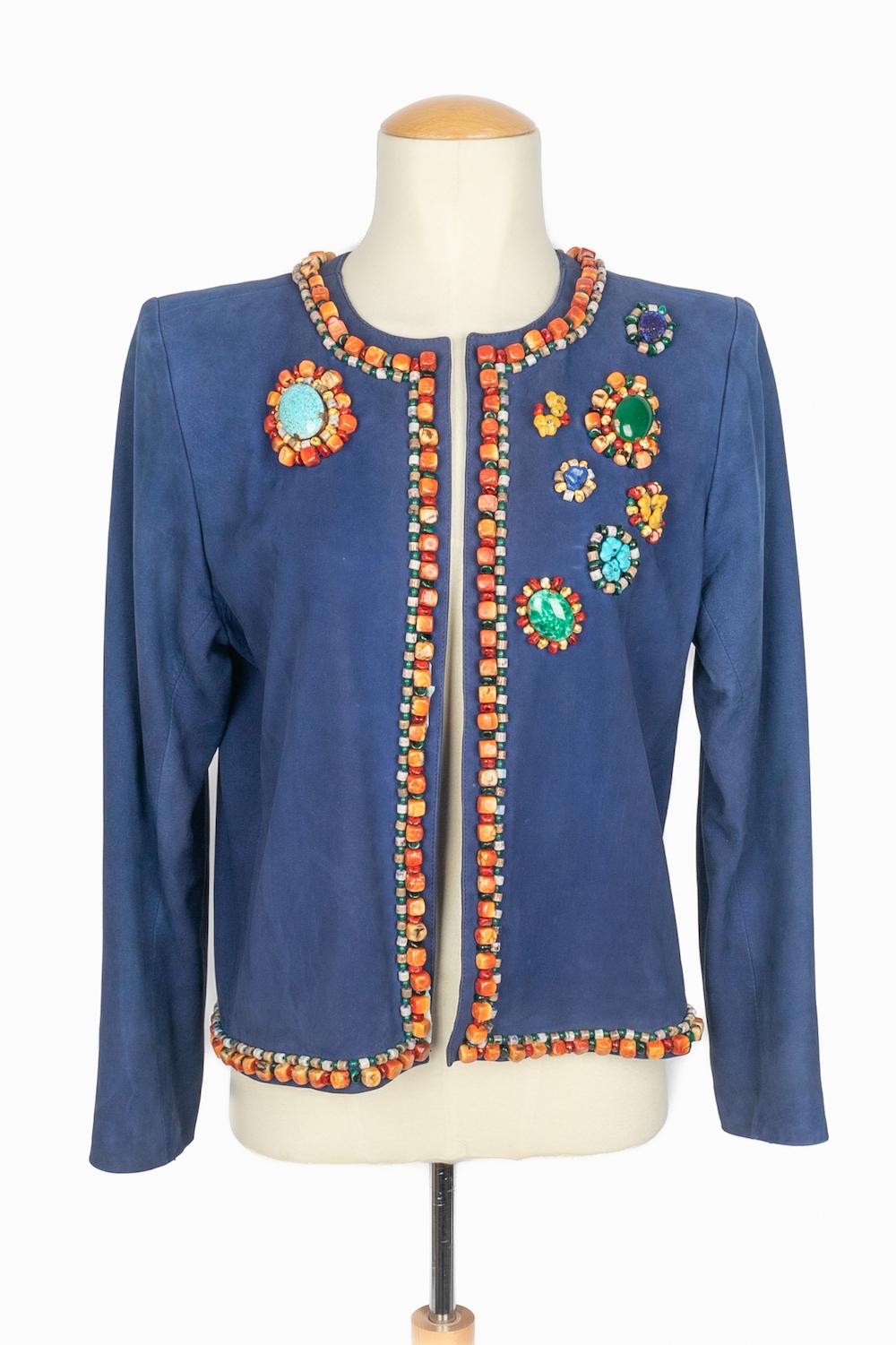 Yves SAINT LAURENT - (Fabriqué en France) Veste en cuir d'agneau bleu ornée de perles et de cabochons en pâte de verre multicolore. Taille 38FR indiquée. Collectional automne-hiver 1993 sous la direction artistique d'Yves Saint Laurent.

Condit
