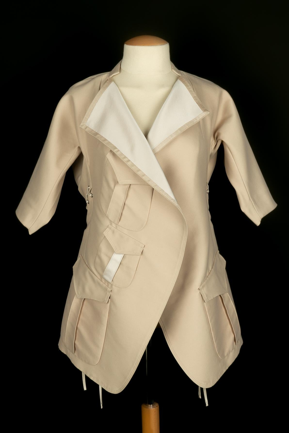 YVES SAINT LAURENT - (Fabricado en Francia) Chaqueta de algodón de seda beige con encajes y elementos metálicos plateados. Talla 38FR indicada. Colección Primavera-Verano 2009 bajo la dirección de Stefano Pilati.

Estado:
Muy buen