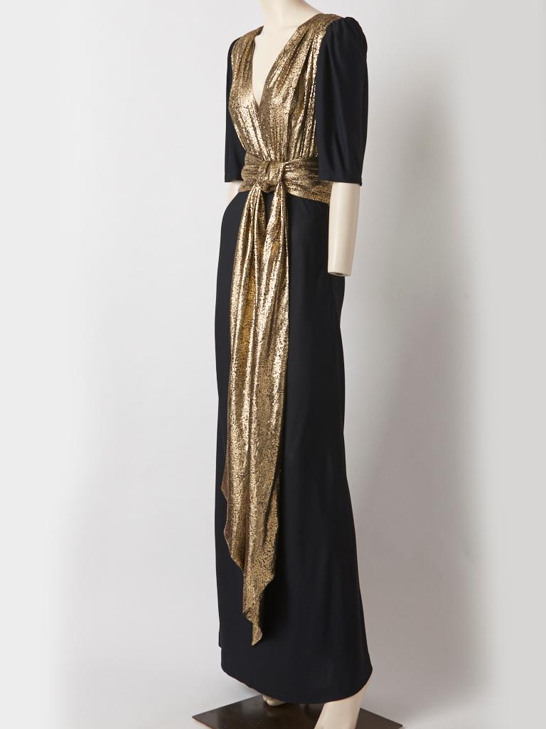 Yves Saint Laurent, Rive Gauche, 1940's inspired gown, in a matte jersey and a reptile pattern, gold lame fabric. The gold lame bodice has a deep V with a slightly padded shoulder and a black jersey sleeve that ends at the elbow. The draped skirt is