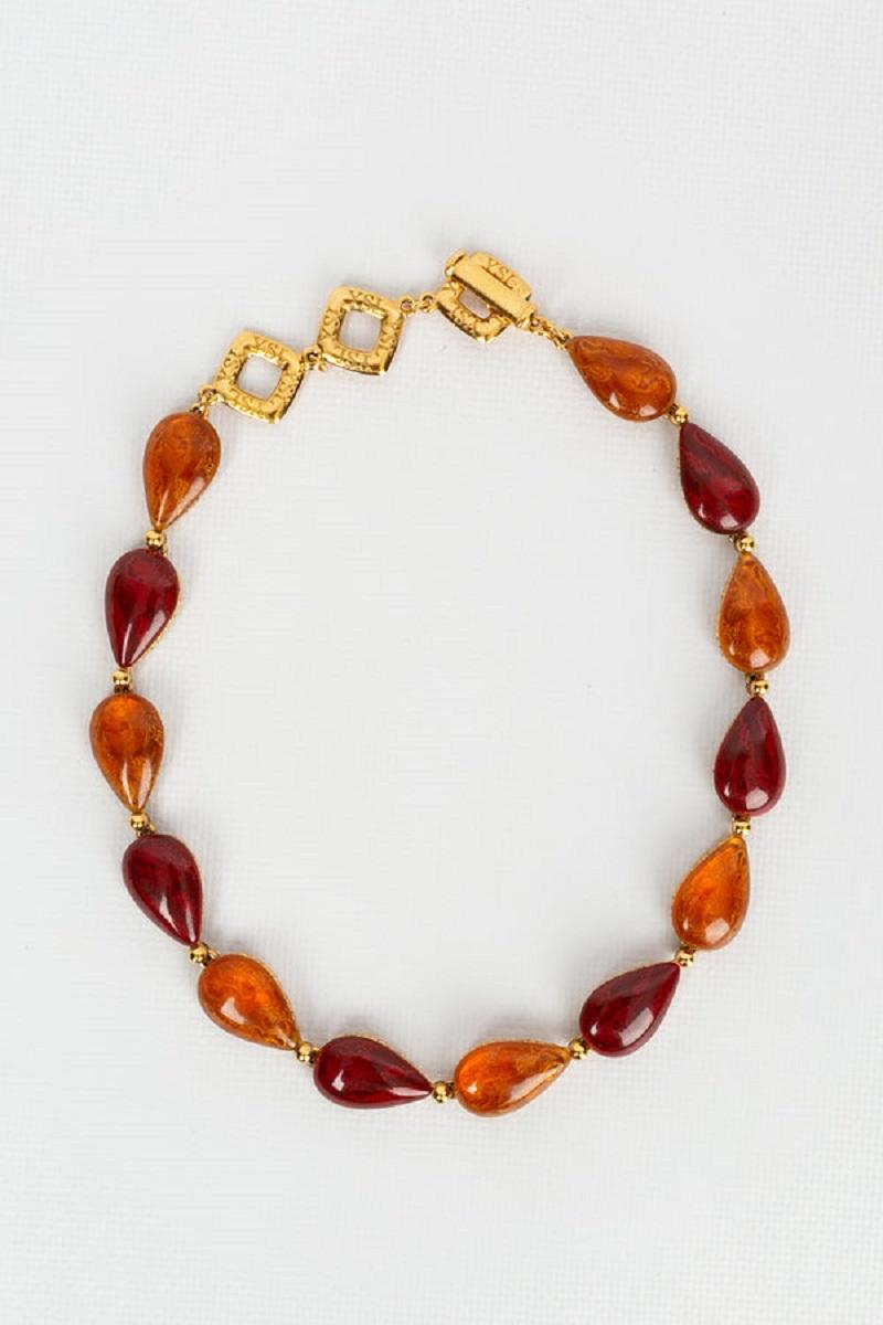 Yves Saint Laurent (Made in France) Set comprised of a short necklace and a bracelet, composed of gilded metal paved with red and orange resin cabochons.

Additional information:

Dimensions: 
Necklace: Length: 39 cm to 44 cm (15.35