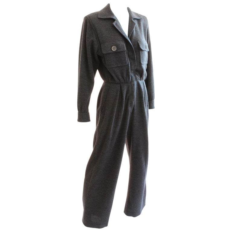 Here's a fabulous charcoal gray wool jumpsuit from Yves Saint Laurent Rive Gauche, likely in the early 1990s. Made from 100% wool, this piece features chest pockets and hip pockets, and long sleeves which can be pushed up to the elbows. Partially