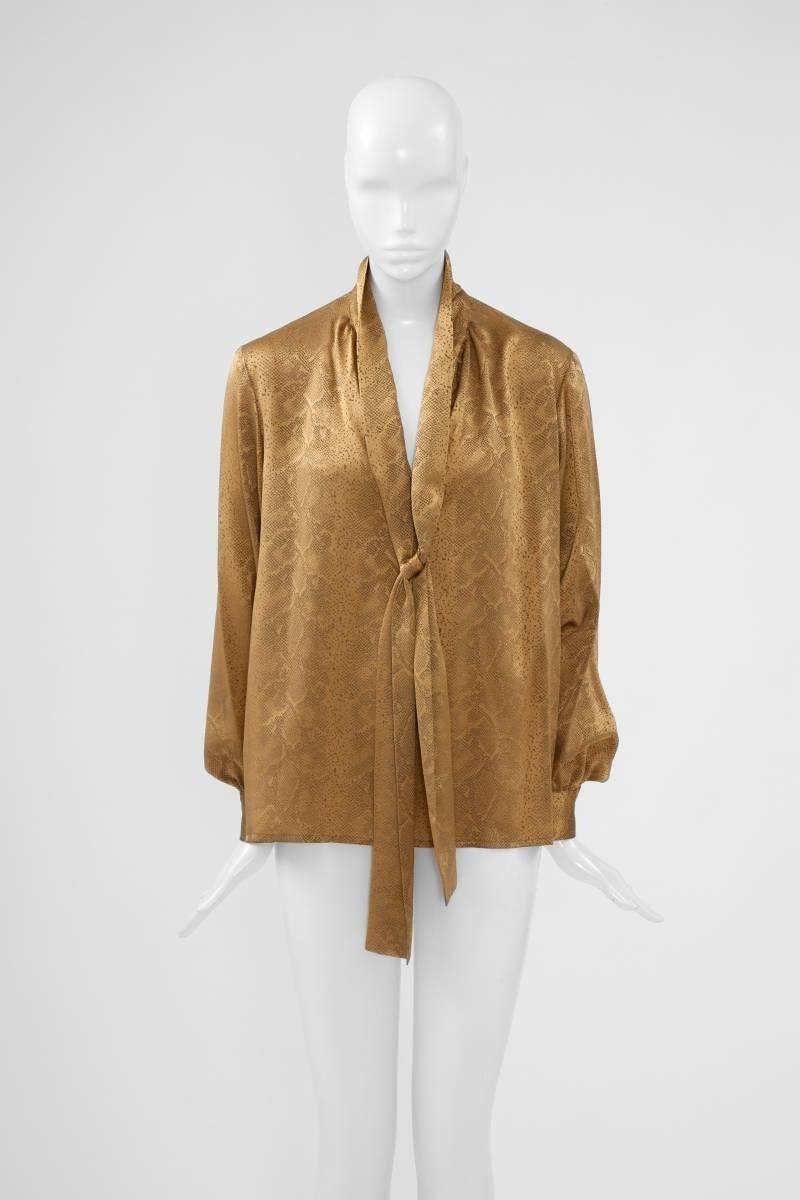 Incredible gold tobacco snakeskin-like silk jacquard over blouse. Blouson sleeves and generous lavaliere tie for a possible pussycat bow. Labelled a French size 38 (US 4-6), the blouse runs a bit big to size. 

Fits approx. : US 6-8 / FR 38-40