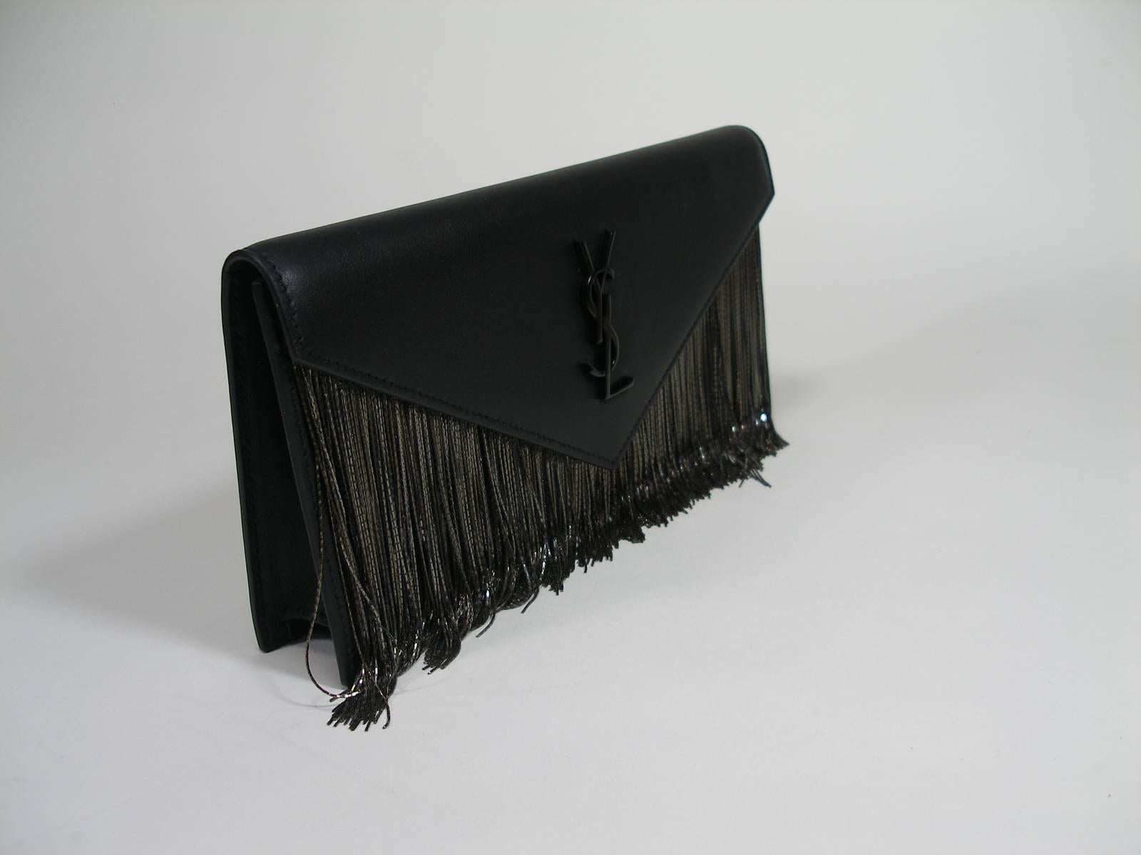 Yves Saint Laurent Metallic Fringes clutch bag in black leather
Sold out every where 
Magnetic snap button
YSL in metal 
Metal chain fringes.
Dimensions 24 X 12 X 4 cm
100% Calfskin leather
Matte black metal hardware
Its comes with YSL dustbag ,