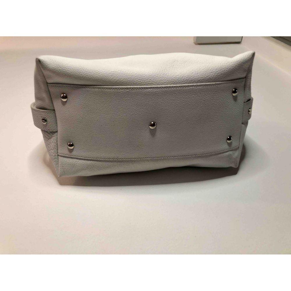 Yves Saint Laurent Leather Handbag in White

Yves Saint Laurent white leather bag with silver hardware. A trapezoid but with two side clip buttons to make it even more capacious. It has some small signs of use, mainly in the part on the back where