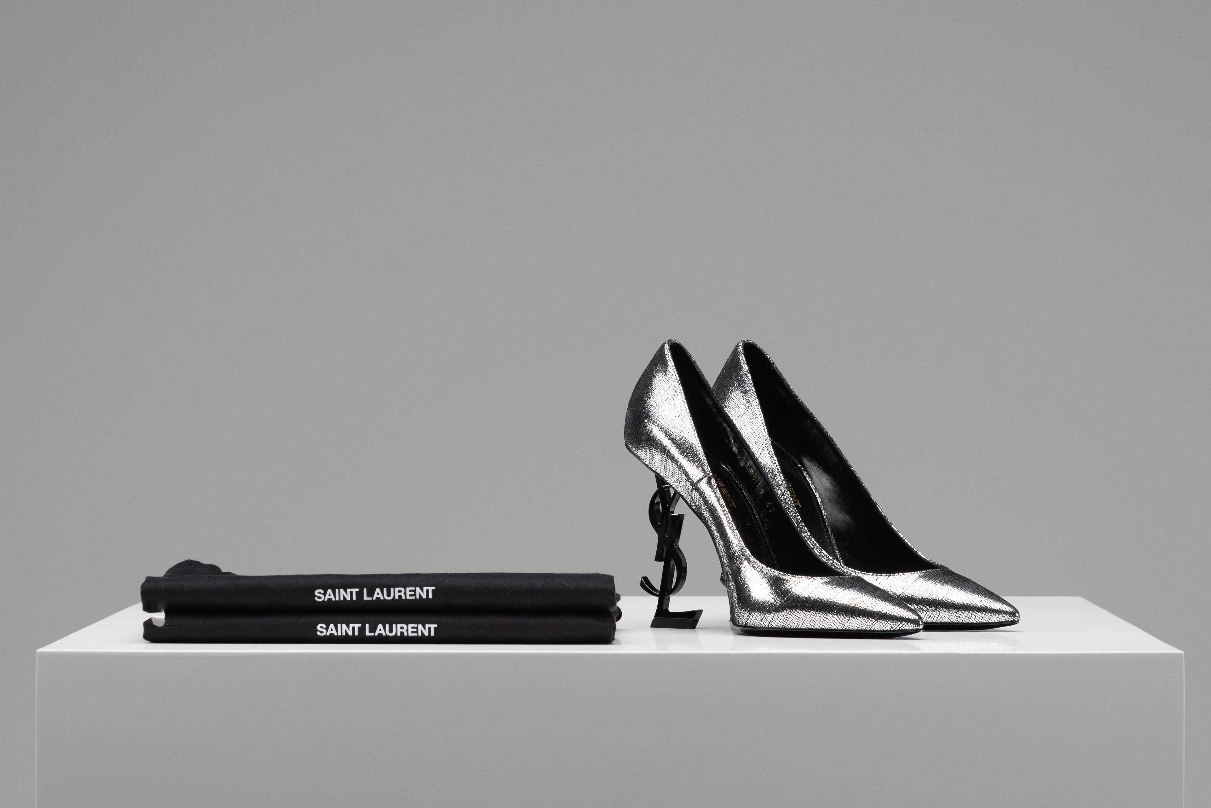From the collection of SAVINETI we offer this pair of YSL Opyum Heels:

- Brand: YSL
- Model: Opyum Heels
- Color: Silver/ Black
- Size: 37
- Condition: Excellent Condition (as new)
- Materials: Leather
- Extras: Dustbag

Authenticity is our core