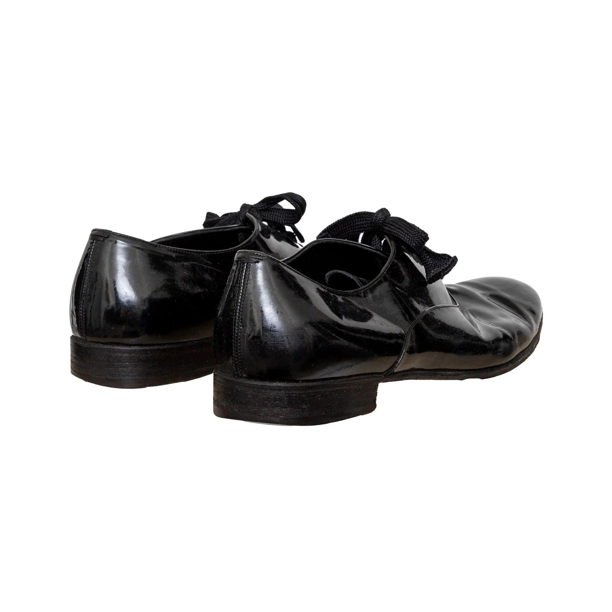 Yves Saint Laurent black patent leather shoes with sleek tapered toe. Classic formal lace-up design with glossy finish for sharp, structured styling. 
 Remarks: there are some signs of wear and fading on the insole. 
 Material: Leather 

