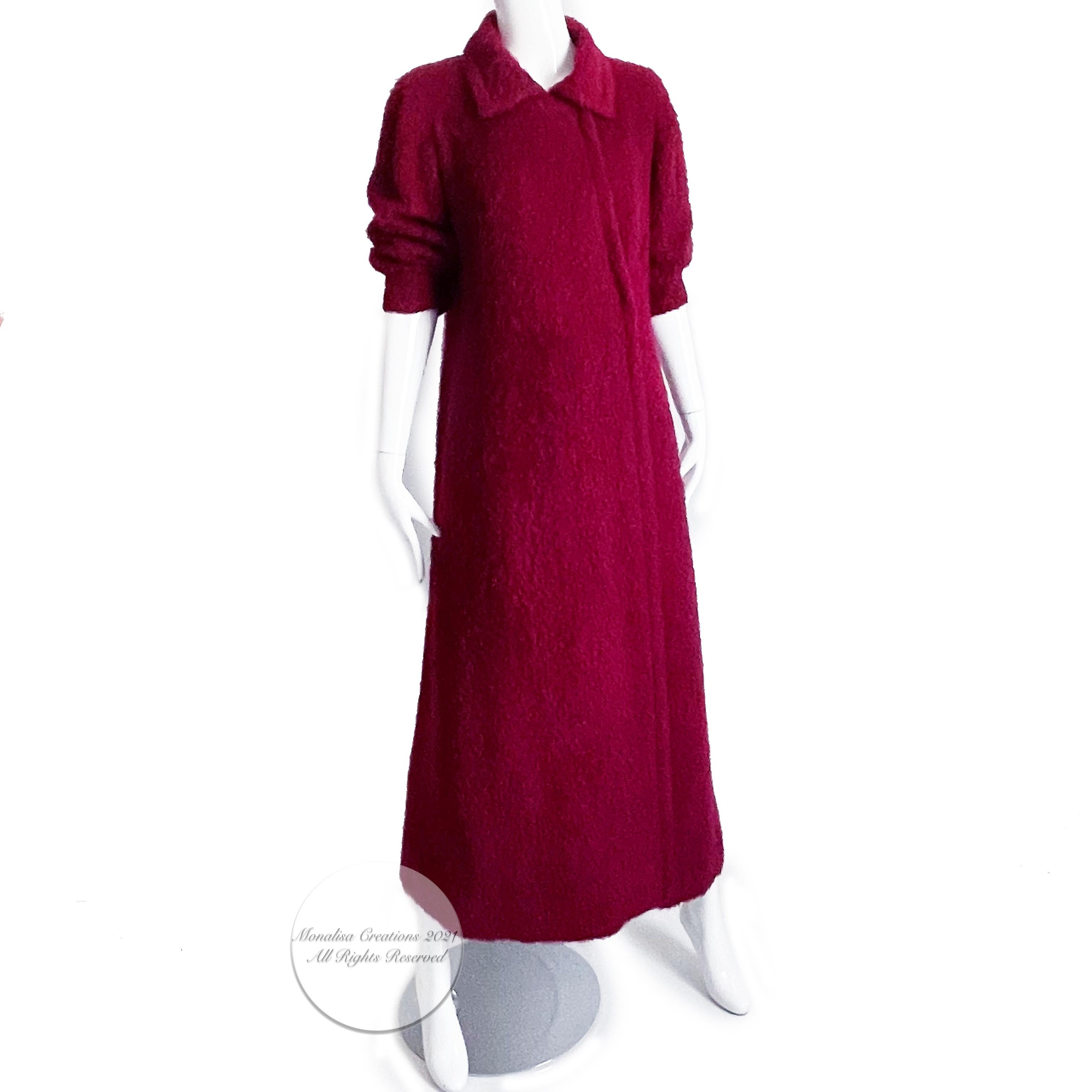 Preowned, vintage Yves Saint Laurent long coat, circa the 60s.  Made from a cranberry boucle wool knit, it has 3/4 sleeves, hidden snap closures, and is lined in pink silk.  No content or size label/dry clean recommended.  Preowned/vintage (50+