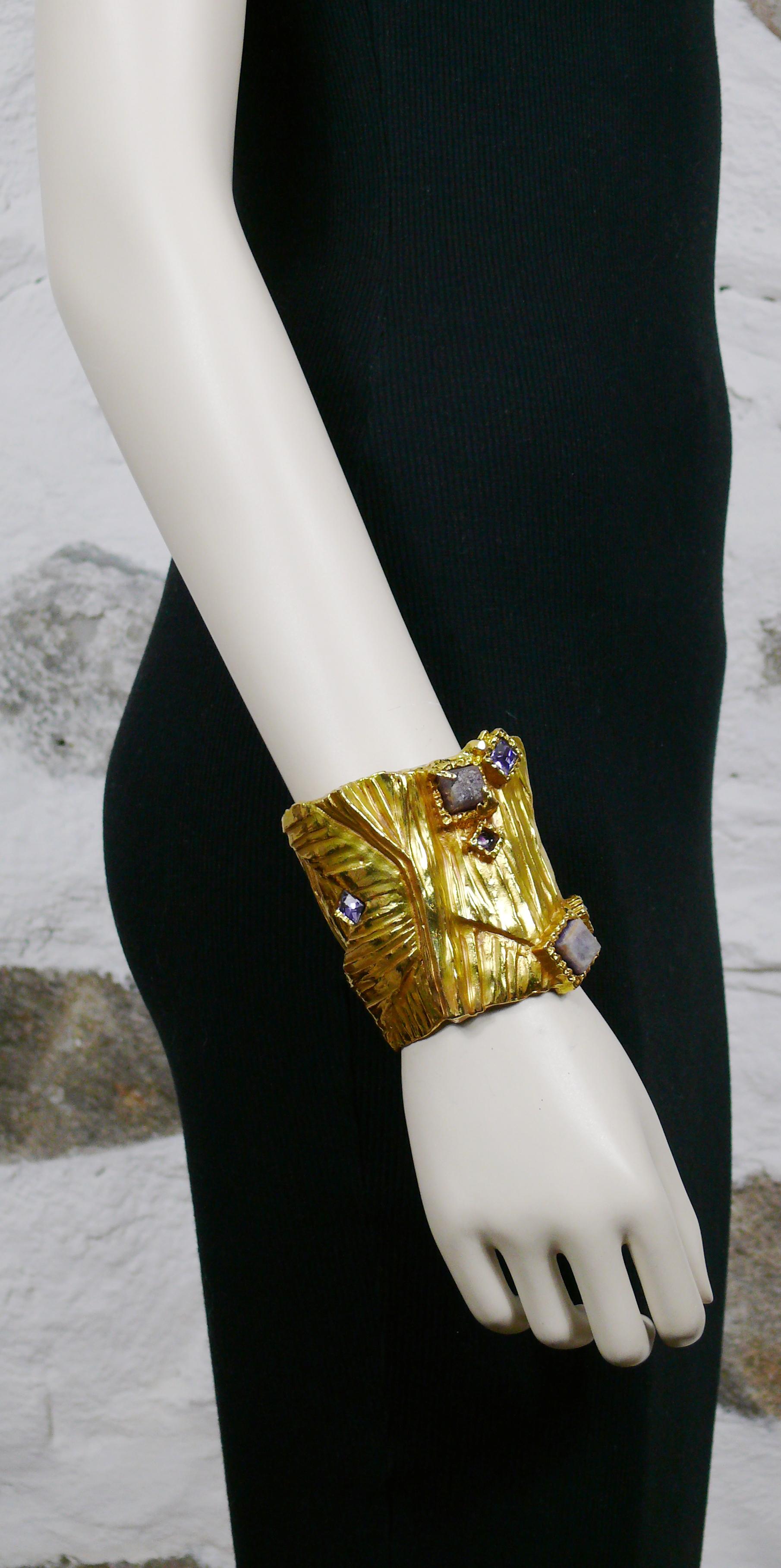YVES SAINT LAURENT massive ARTY gold toned ribbed texture cuff bracelet embellished with hard stones, crystal and enamel. Stylized Y initial.

Embossed YVES SAINT LAURENT.

Has weight on it (approx. 300 grams).

Indicative measurements : inner max.