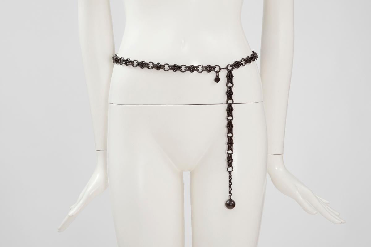 This weighty 70’s YSL gunmetal-tone belt is crafted from interlocking metallic chain links, some of which feature a delicate motif (see pictures 5 & 6). The end of the belt is embellished with a little ball. It fastens with a hook closure that