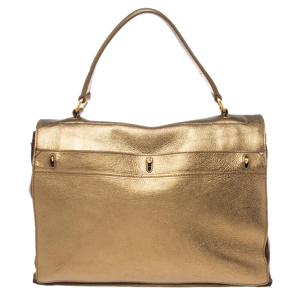 This metallic gold Yves Saint Laurent bag is an all-season accessory. Crafted from leather on the exterior, it is held by a top handle and features a front lock and gold-tone hardware. The suede interior is equipped with a zipper pocket for your