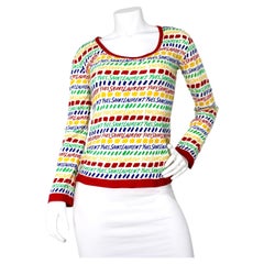 Yves Saint Laurent Top a maniche lunghe in cotone con stampa logo multicolore, circa anni
70