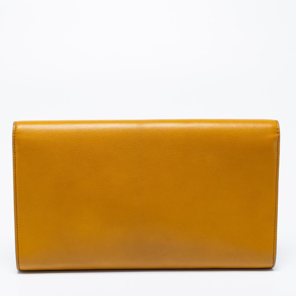 This flap clutch from Yves Saint Laurent is an elegant accessory suitable for any occasion. A large YSL logo adorns the front and gives it a luxe slant. The flap closes with a snap fastener and the interior is sized to fit your little