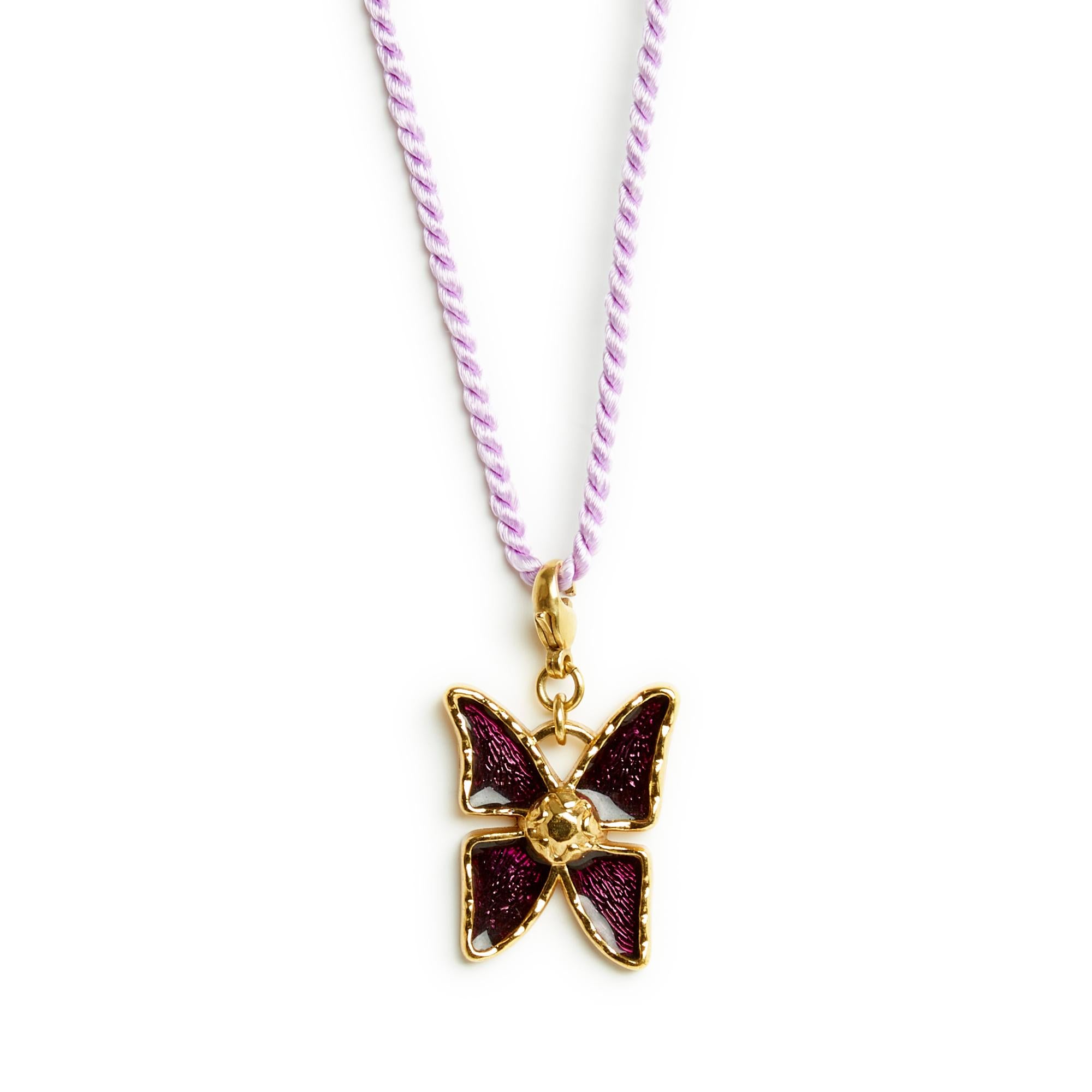 Yves Saint Laurent pendant charm with the motif of a butterfly in gold metal decorated with purple enamel, mounted on a carabiner, signed. Total length 4.4 cm, width 2.7 cm. The pendant is vintage, in very good condition, delivered on a trimmings