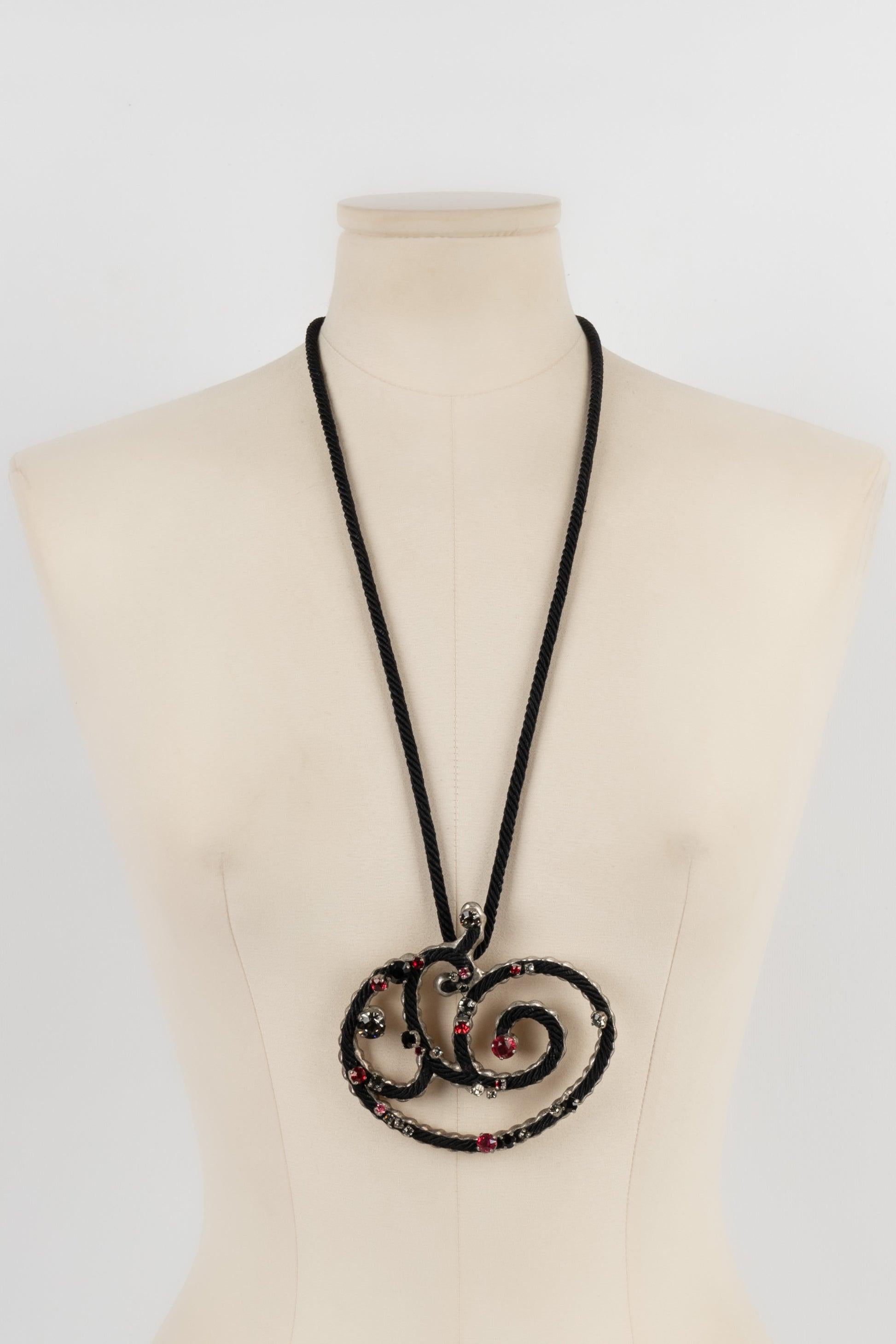Yves Saint Laurent - Necklace with a black trimmings link holding back a silvery metal, trimmings, and rhinestone pendant.

Additional information:
Condition: Very good condition
Dimensions: Length: 77 cm

Seller Reference: BC148